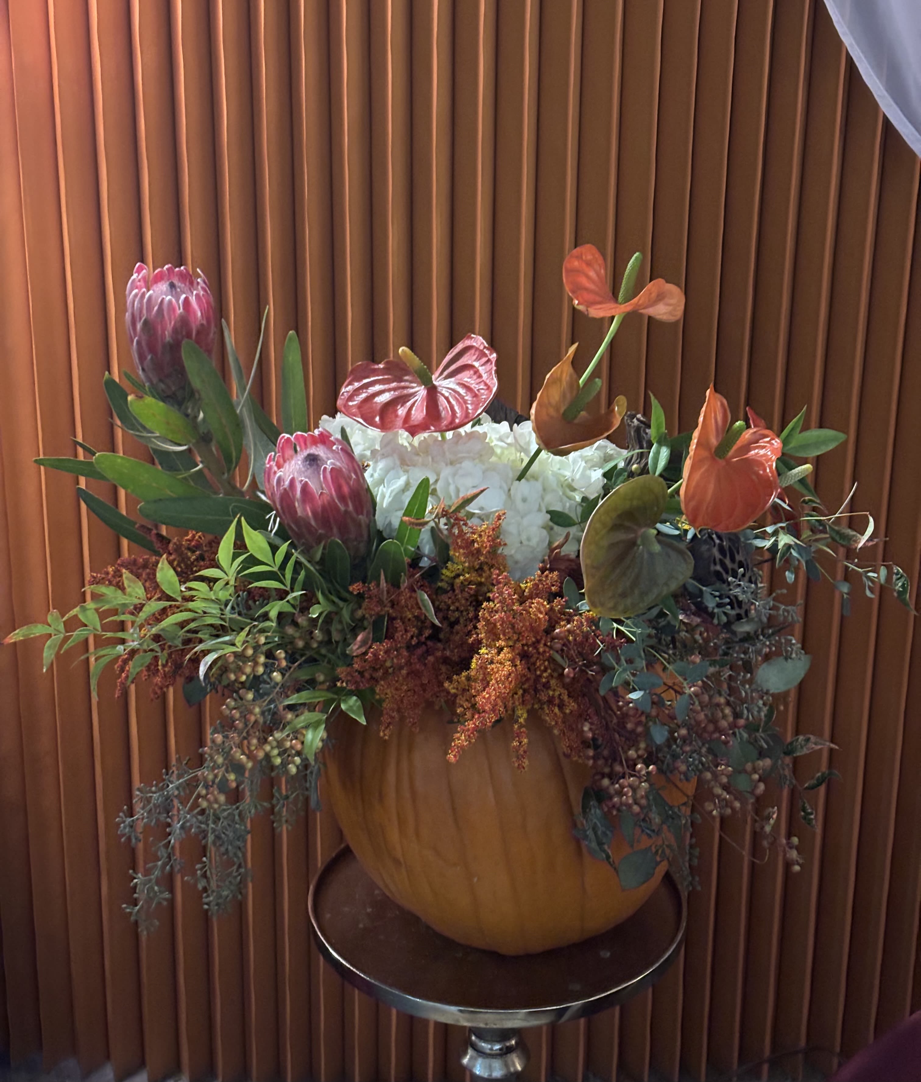 Golden Pumpkin Bloom - An autumnal design full of warmth with golden and orange flowers in a natural pumpkin, perfect for decorating your home or seasonal events. Designed by RMC Floral Designs – Seattle florist.
