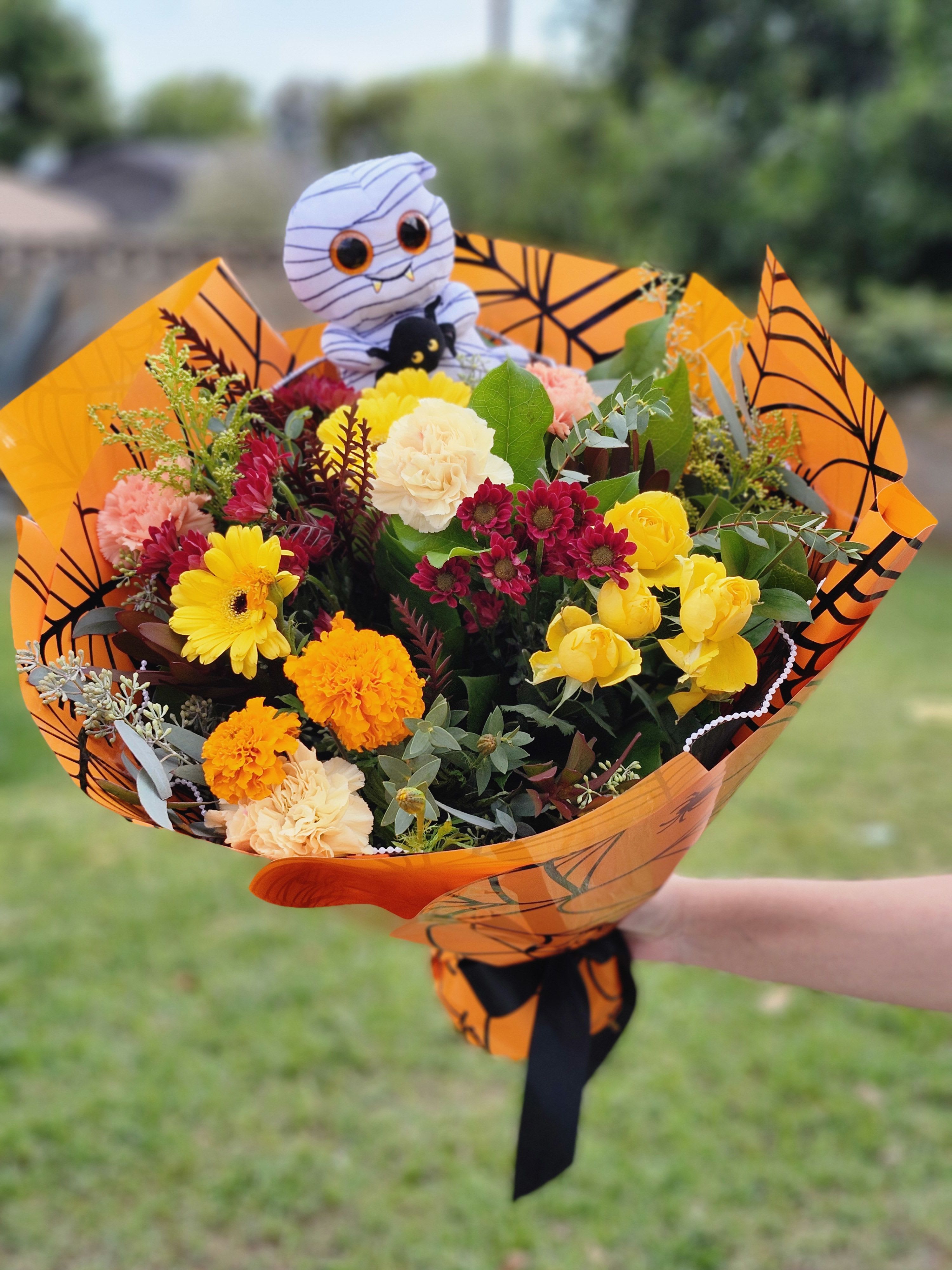 Halloween wrapped bouquet  - Designer's Choice fall flowers with Halloween theme paper