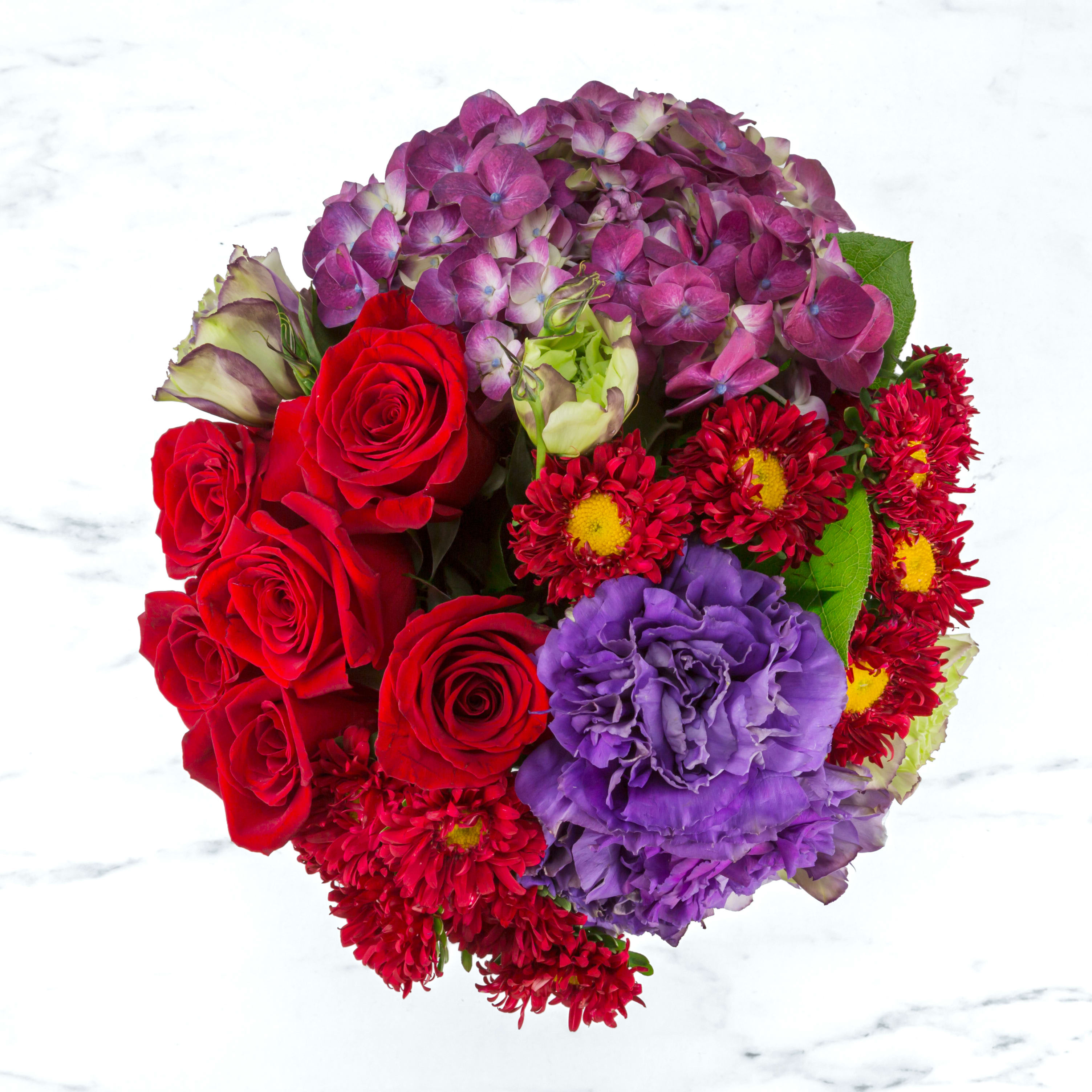 Garnet by BloomNation™ - This deep jewel tone arrangement featuring red roses, purple hydrangea and purple lisianthus is a dream. Garnets symbolize higher thinking and are the birthstone for January making this a great wintertime birthday present or congratulations for an academic or career win.  Approximate Dimensions: 11&quot;D x 11&quot;H