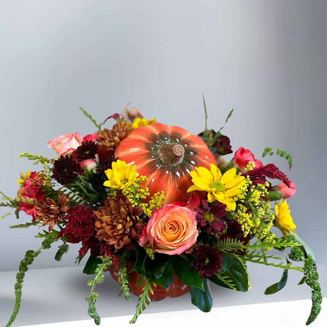Pumpkin to my Pie in Cookie Jar - Type of Flowers:  Fall Daisies, Orange Roses, Dahlias, Pink Alstroemerias, and Peach Mini Carnations, and Dusty Miller in a short pumpkin, ceramic cookie jar pot with lid. Availability: All year round Substitute Available: Yes Design View: Symmetric Front Facing View Photo shown: Regular