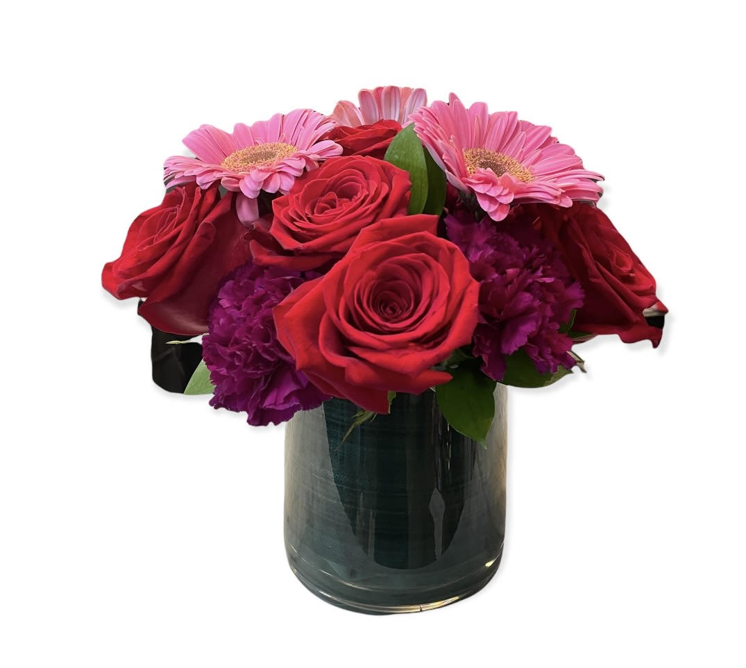 Raspberry Bliss - Gorgeous purples and reds sparkle like jewels against the lovely green of the aspidistra ribbon lined clear glass vase. This medley of burgundy, fuchsia, bright pink and red drips with a decadent feel! Perfect for love and romance, anniversaries, birthdays, and &quot;thank you&quot; sentiments.  Please note that your blooms will reflect the overall style and tone of the pictured arrangement. Exact flower types, colors and vase style may vary and are based on availability.