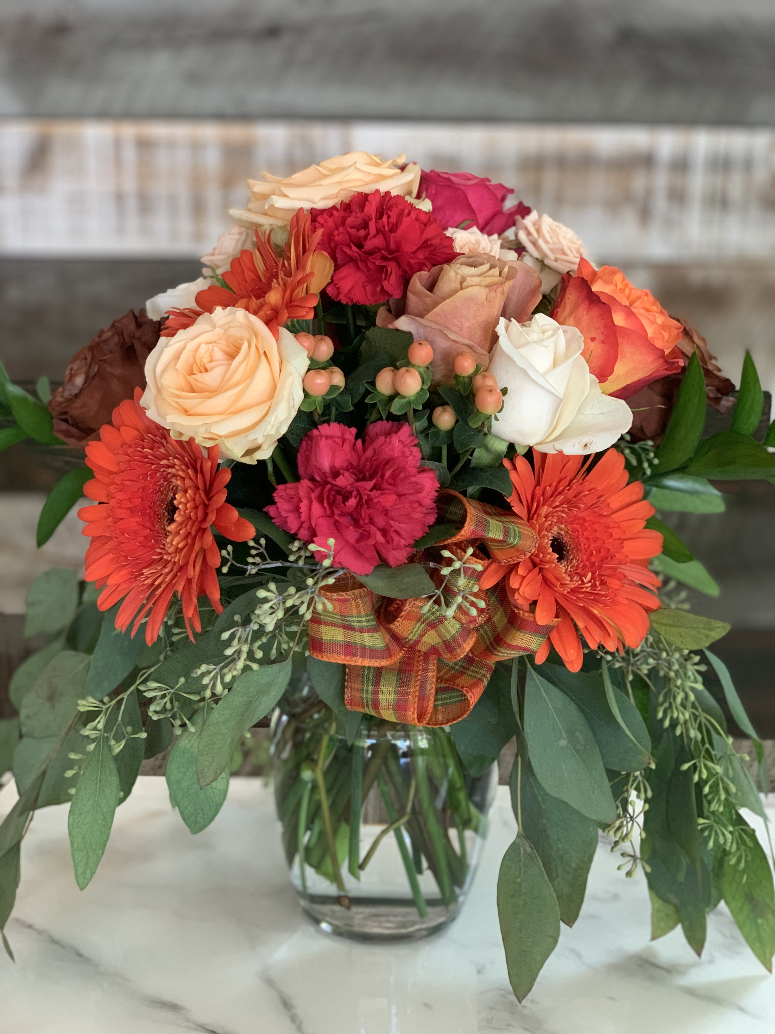 Sweater Weather - This vase is full of some of our favorite flowers. Roses in seasonal colors complimented with sprays and gerberas and accented with a seasonal appropriate bow.