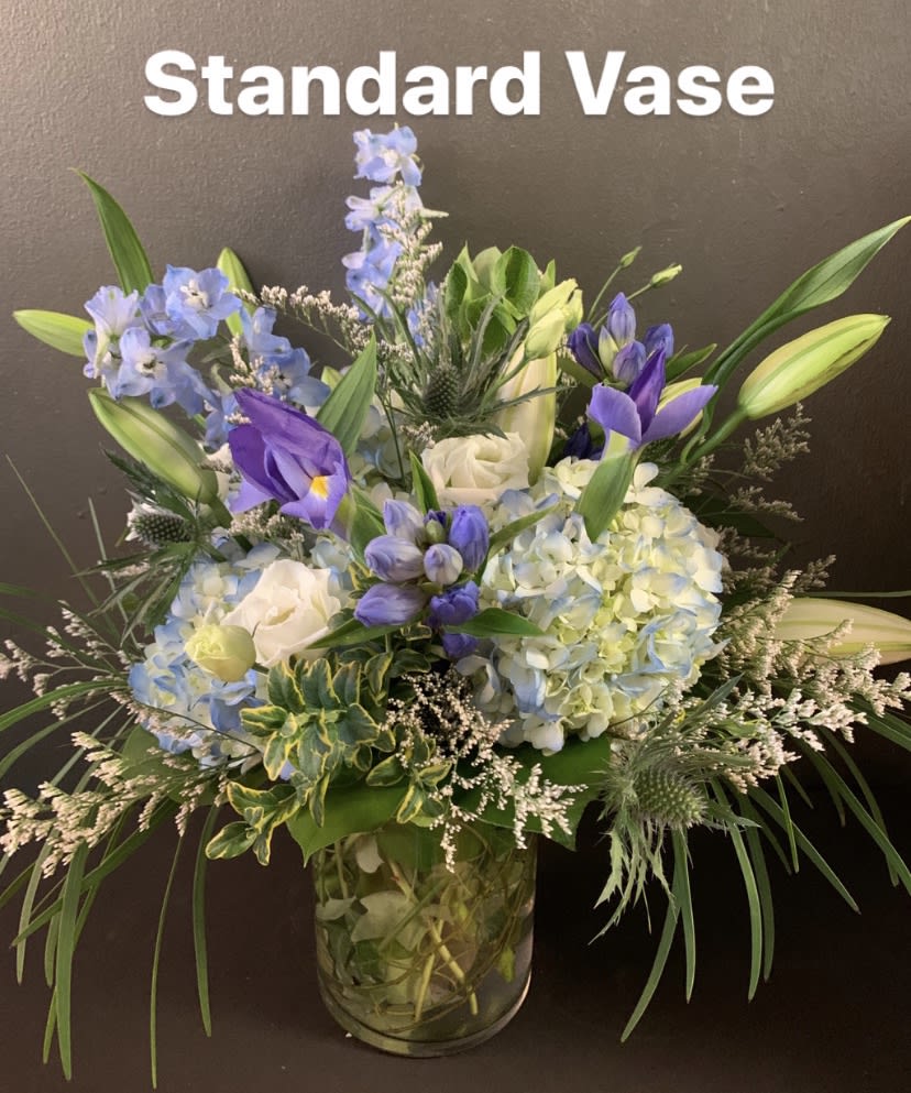 Breezy by the Sea - This arrangement contains delphinium, bells of ireland, lilies, hydrangea, blue iris, and other seasonal blooms.