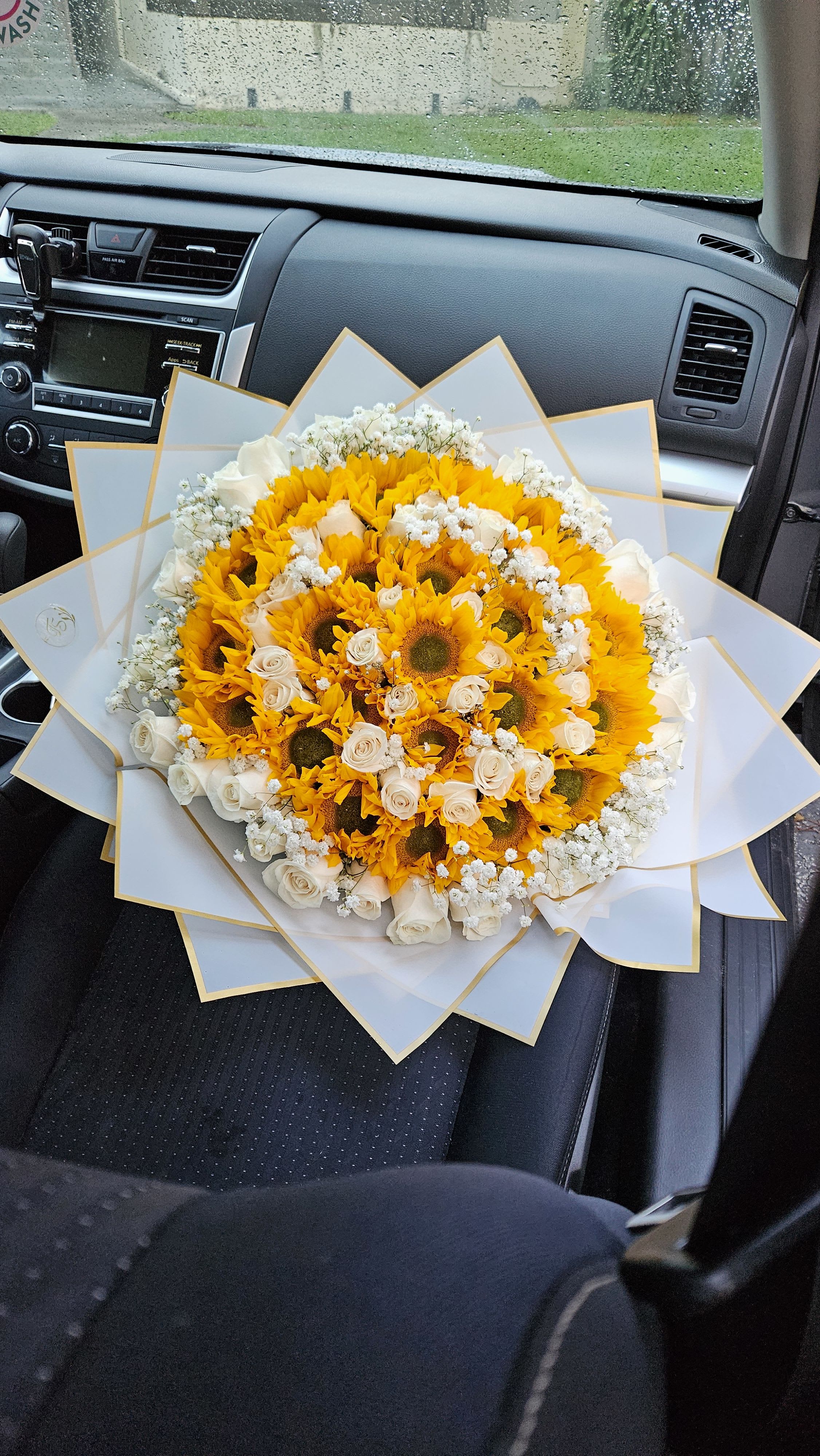 Ramo buchón de rosas y girasoles  - Eleva cualquier ocasión con nuestro impresionante Ramo Buchón, una combinación perfecta de elegancia y alegría. Este arreglo destaca por la pureza de las rosas blancas, símbolo de amor sincero y nuevos comienzos, entrelazadas con la vibrante energía de los girasoles, que irradian felicidad y vitalidad. Cada flor es cuidadosamente seleccionada para crear un diseño voluminoso y sofisticado, ideal para sorprender en aniversarios, cumpleaños o simplemente para decir &quot;te quiero&quot;.  El contraste entre el blanco prístino y el amarillo radiante, hace de este ramo una pieza única que captura miradas y corazones. Perfecto para quienes buscan un regalo inolvidable con un toque de lujo y naturaleza. Ideal para eventos especiales o gestos románticos. ¡Haz que su día brille con este espectacular ramo lleno de amor y luz!