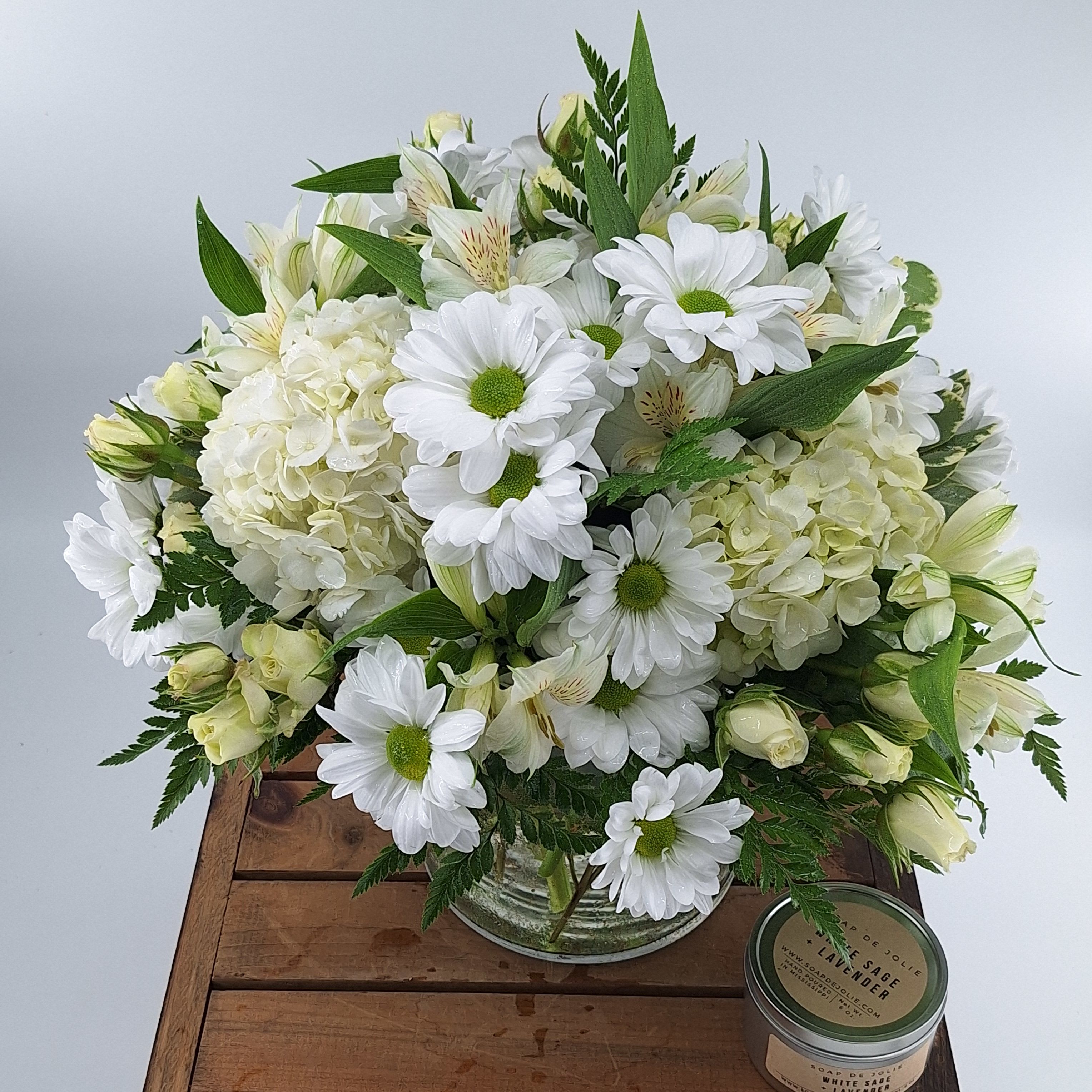 Farewell Friend (BB) - Introducing the "Farewell Friend" funeral flower arrangement, a loving tribute to honor and remember a dear friend. This beautiful arrangement features a delicate blend of daisies, mini spray roses, hydrangea, and alstroemeria, all in a serene and pure white color. Enhanced with premium greenery, this arrangement offers a touch of natural elegance and tranquility.