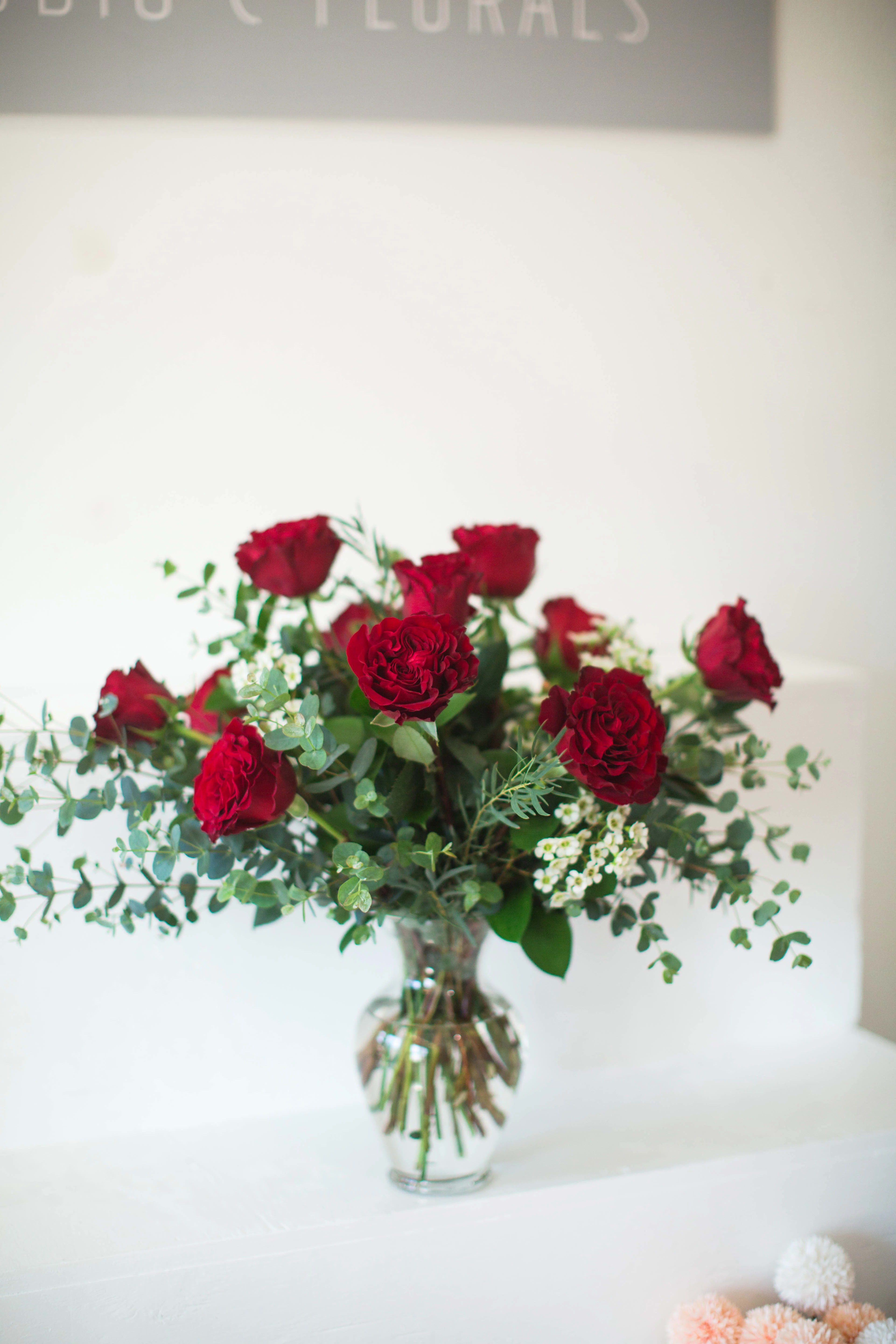 The Newport Dozen - A Studio C Florals signature design - twelve long-stem red roses artfully arranged with lush seasonal greenery and styled in a clear glass vase. Perfect for anniversaries, birthdays, or &quot;just because.&quot;    Available for same-day local delivery or pickup