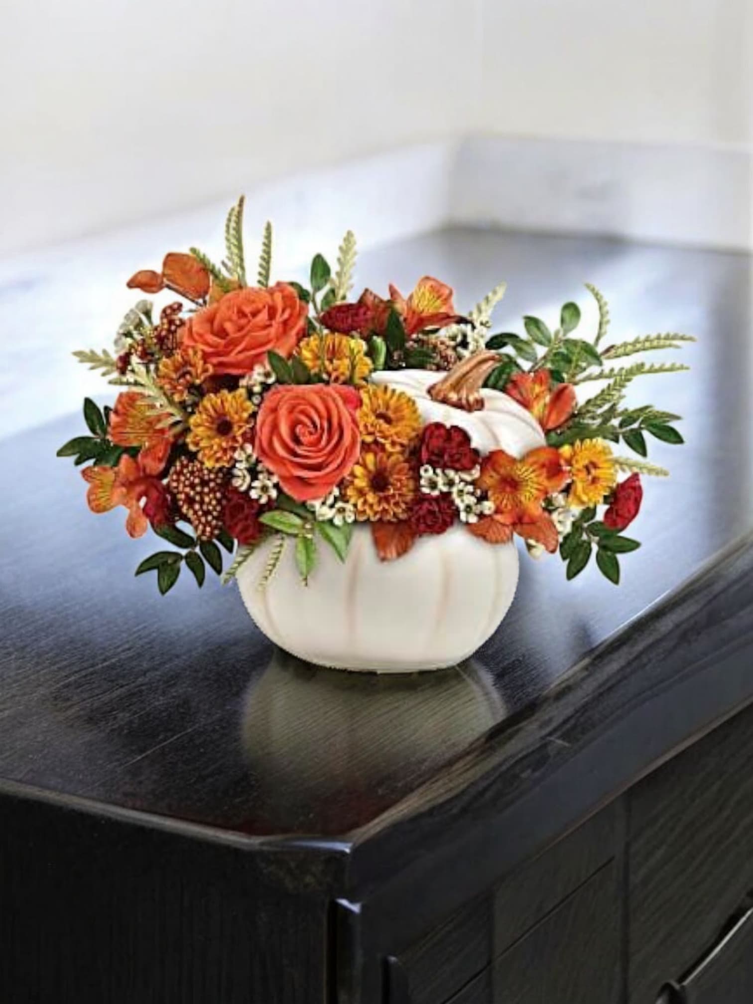 PunkinJul02 - fall mix Orange roses, orange alstroemeria, miniature maroon carnations, and yellow  daisy spray chrysanthemums , grevillea,  and yellow preserved oak leaves. Delivered in a white ceramic punkin