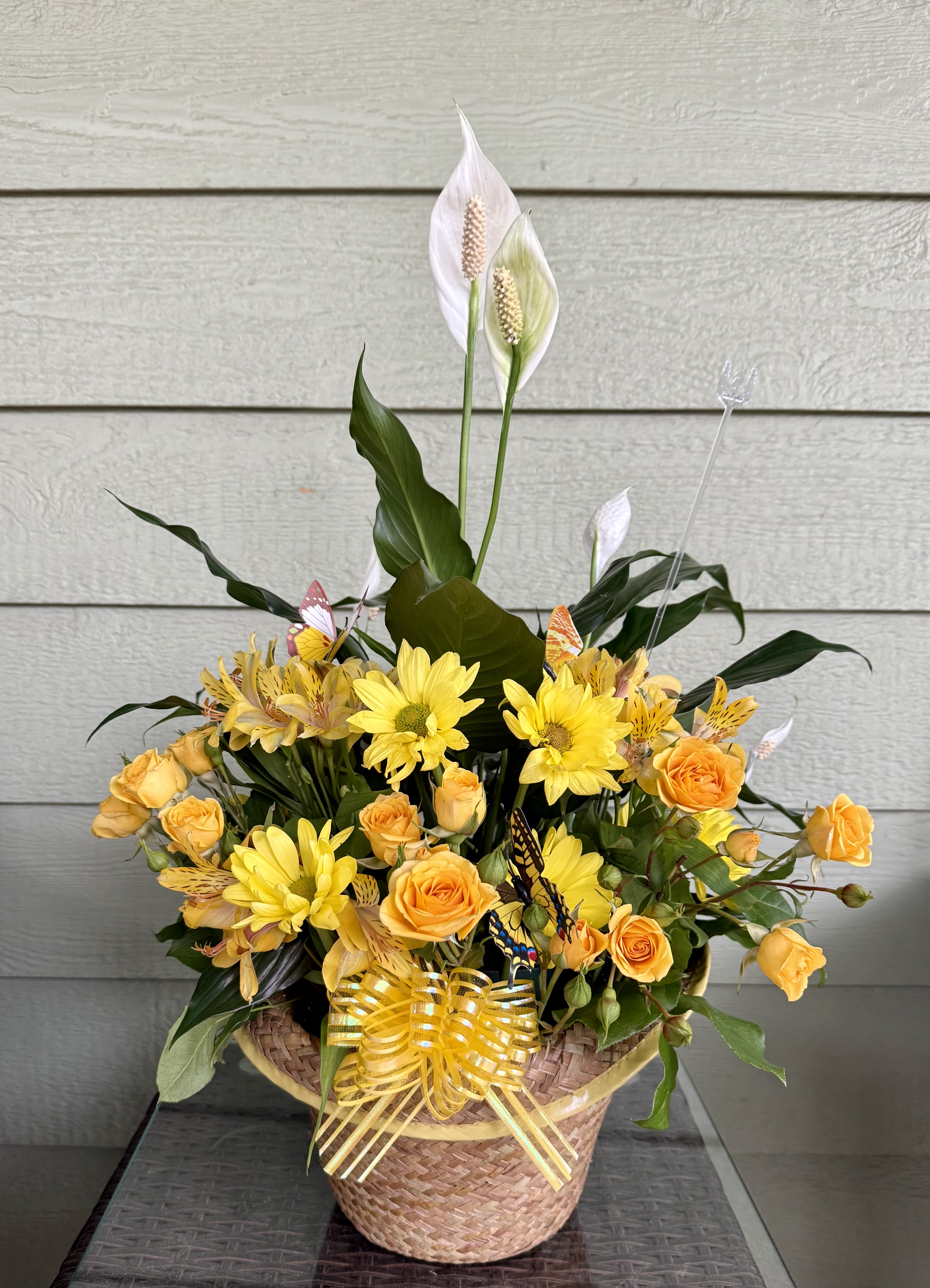 Loving Light of Peace - Send your condolences with this peace lily in a basket filled with yellow flowers to bring a bit of peace, love and light to your loved one. 