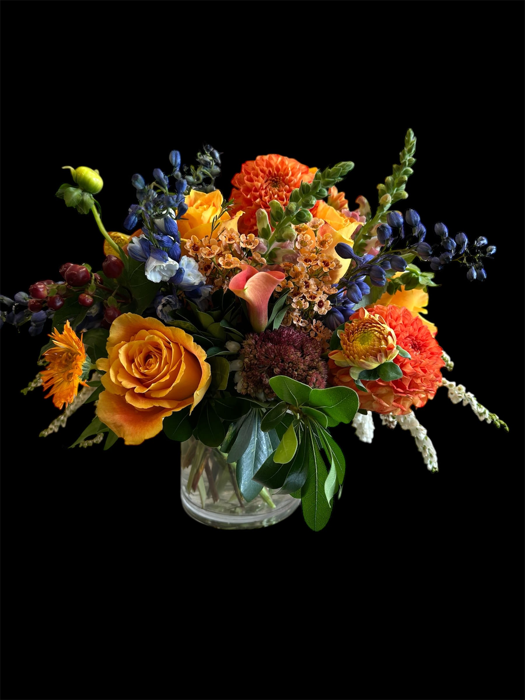 EXPLOSION DHALIAS  - Beautiful arrangement accompanied by a lovely touch of dark delphinium with some orange roses that give it a perfect touch