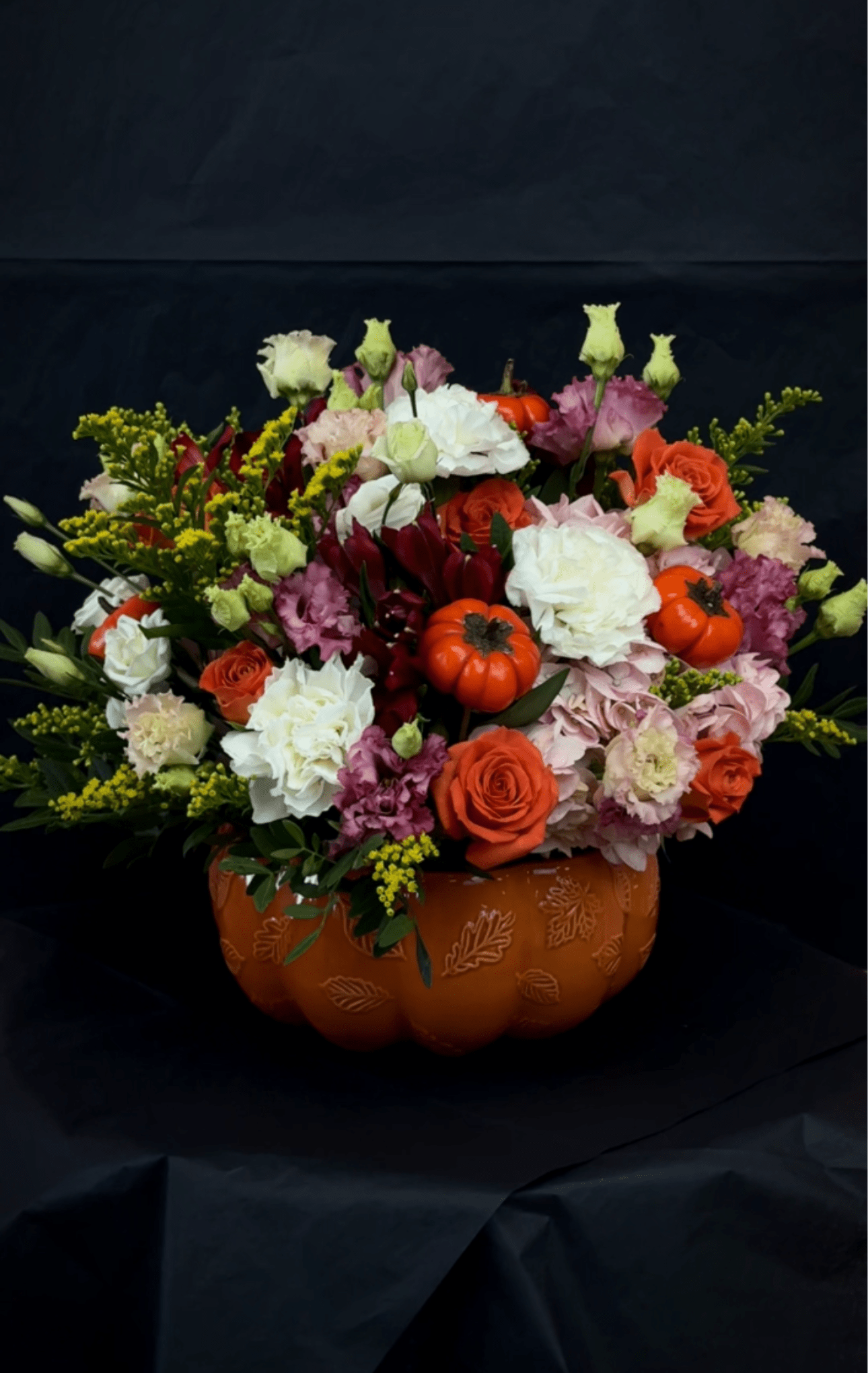 Pumpkin Arrangement - Pumpkin Arrangement, designed in a charming pumpkin vase. Filled with vibrant seasonal blooms in rich shades of orange, yellow, and red, this piece perfectly captures the warm, cozy spirit of fall. Arrangement will not be exactly the same, but style and colors will match. 