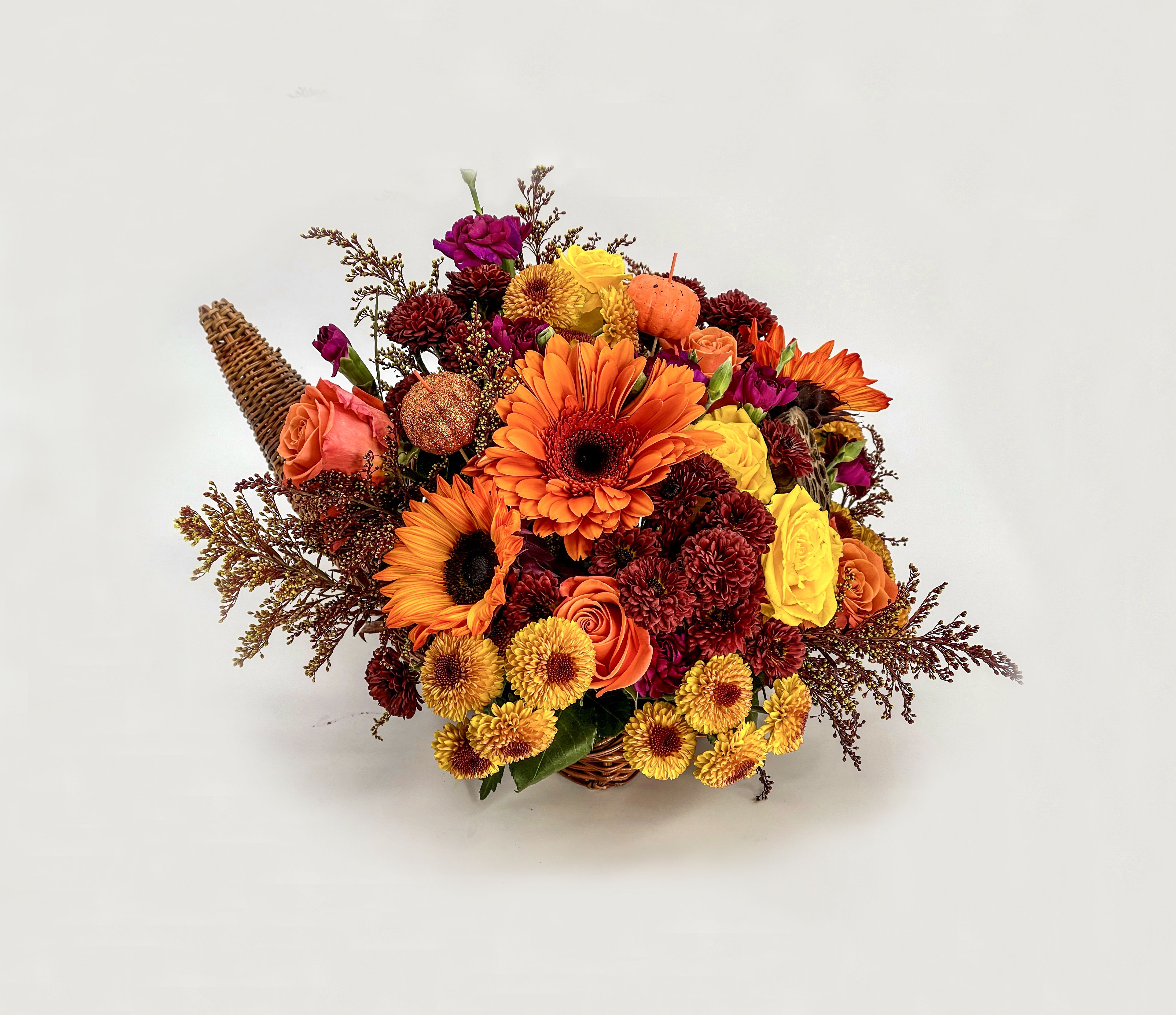 Harvest Blessings - This Arrangement, with its warm oranges, yellows, and rich reds in a Cornucopia basket, has a beautiful harvest and Thanksgiving Feel.