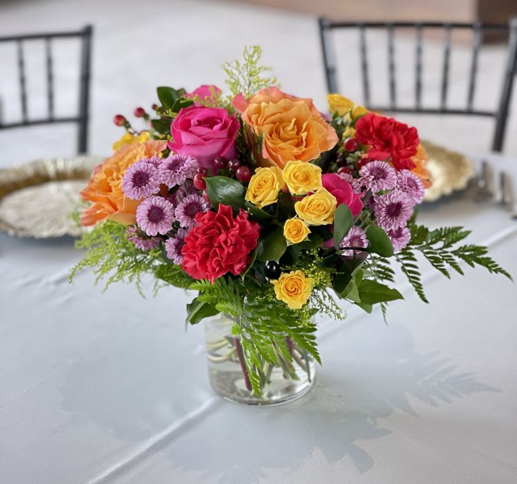 Sweet Spring Bouquet - A colorful bouquet of red, hot pink and orange and yellow Roses and mini Roses and carnations, with purple accent flowers.