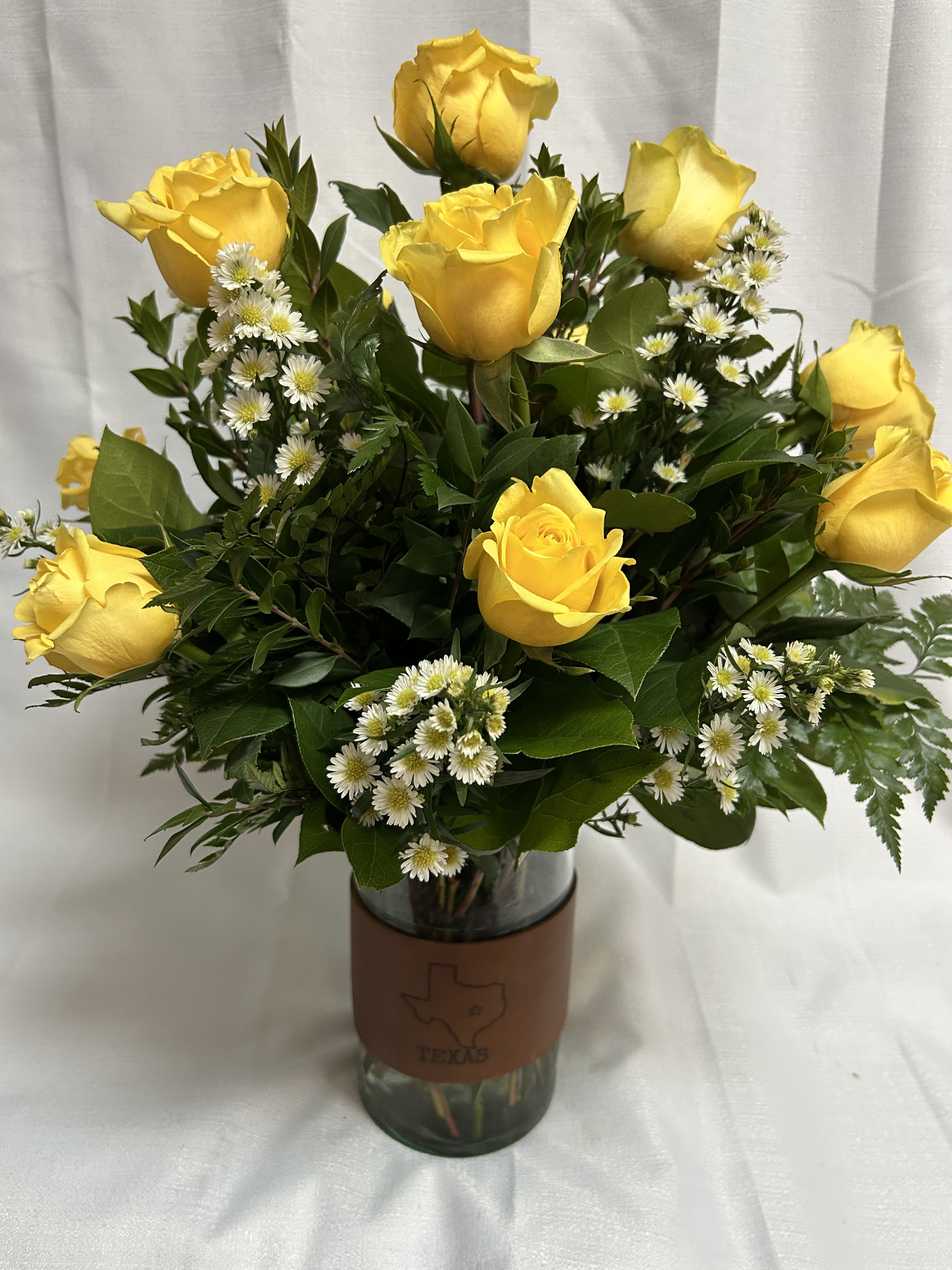 Yellow Roses of Texas - A dozen yellow roses are beauitfully displayed in our one of a kind leather banded vase that displays the emblem of the great state of Texas. 