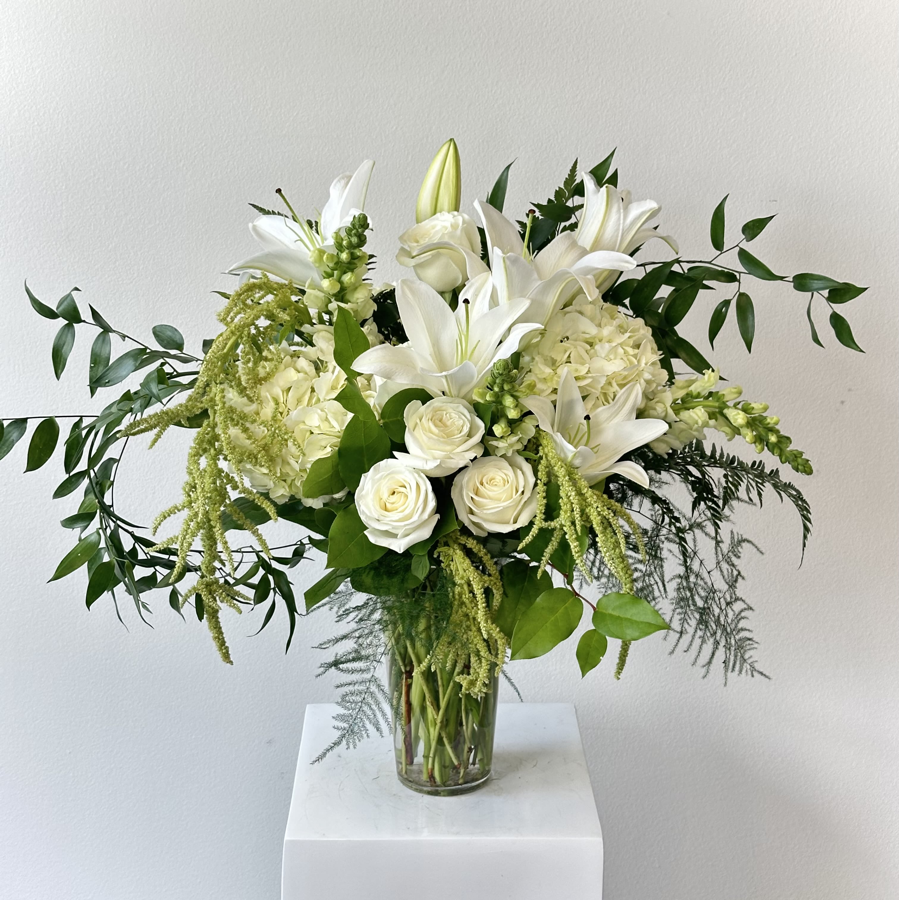 Lovely Lillies - Lillies hold great value to the world - throughout culture and literature they remain not only lovely but influential. This arrangement encompasses timeless beauty with prominent white lilies, white hydrangea, and italian ruscus. 