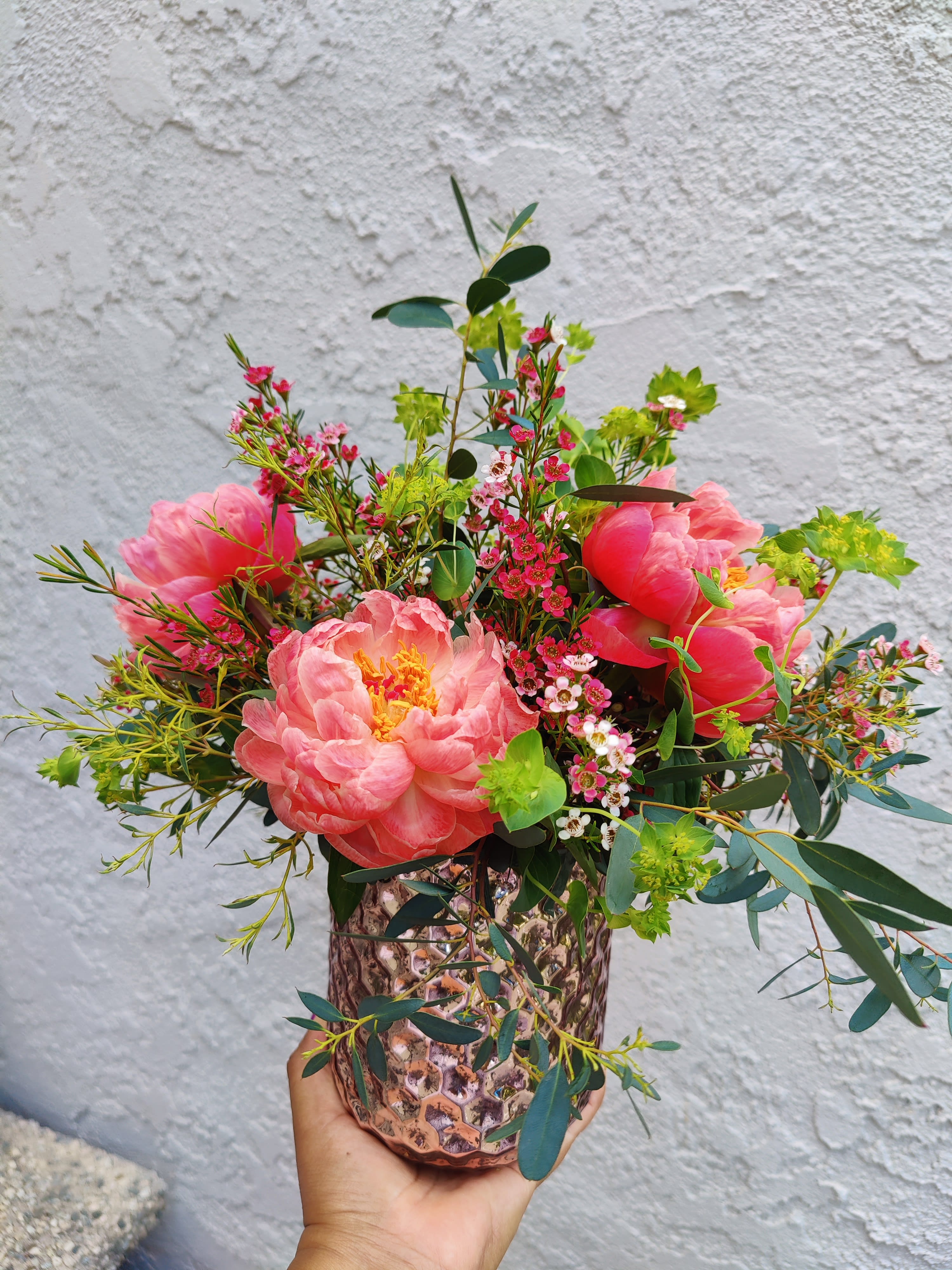 &quot; Coral Charm Peonies &quot; Centerpiece - Beautiful seasonal peonies accented with fragant wax flowers and a variety of fresh foliages. Size medium . It includes 5 coral peonies Vase might vary depending on availability. Recipient will always receive a high quality ceramic vase.     