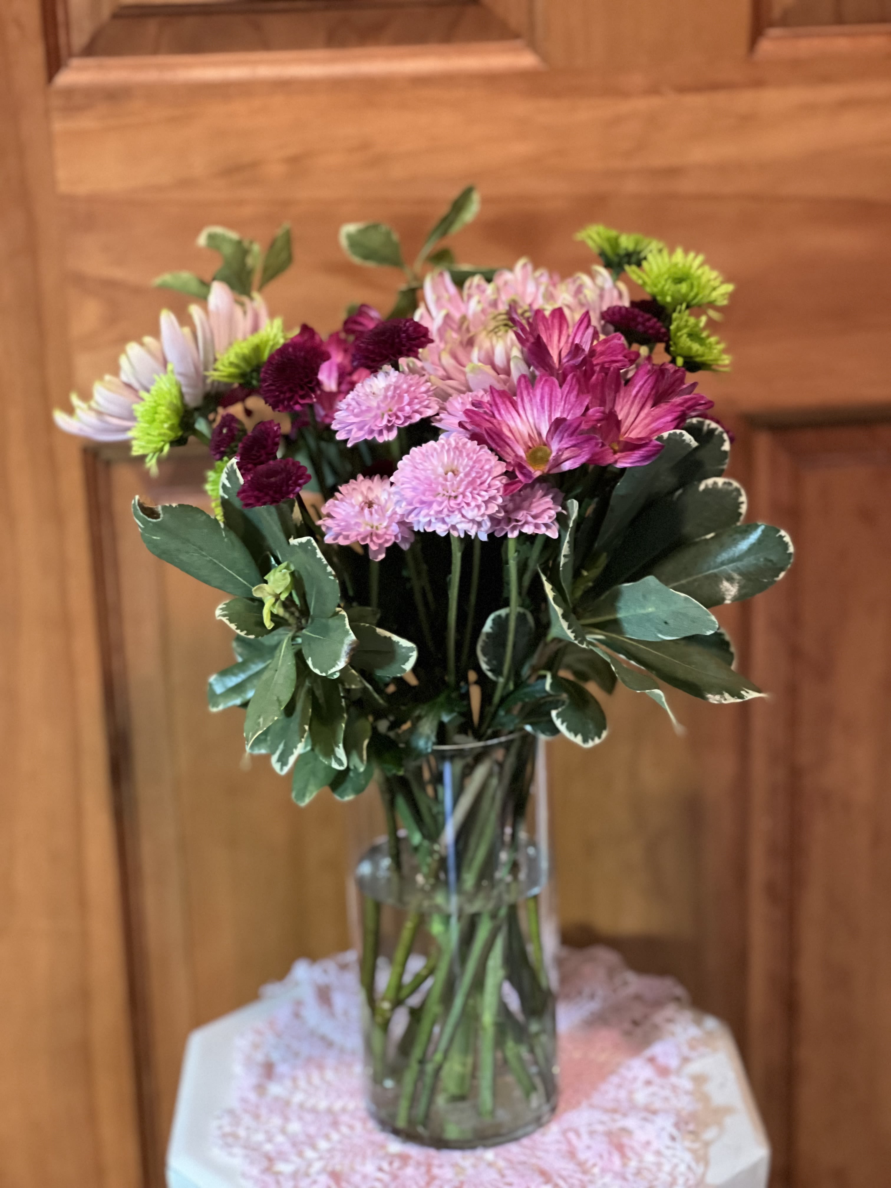 Pink and purple chrysanthemum bouquet in a clear glass vase