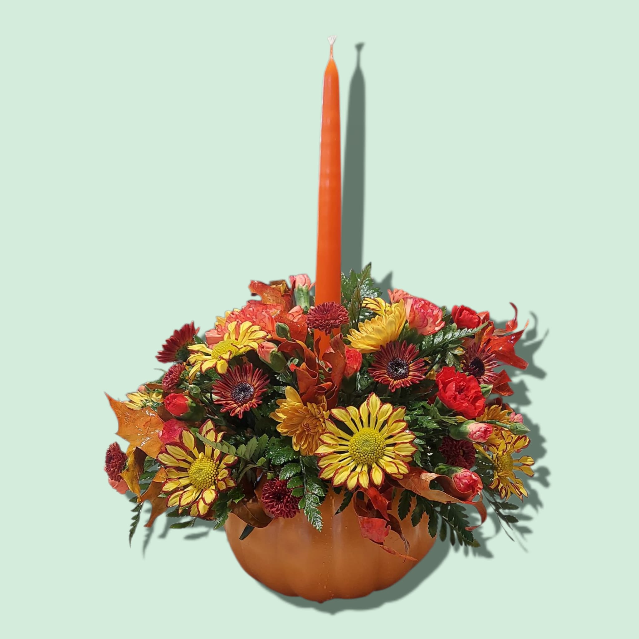 Pumpkin Candle Centerpiece - A ceramic pumpkin featuring a single tapered candle surrounded by fall colored chrysanthemums. Approximately 11&quot; W x 9&quot; H, with candle 11&quot;W x 16&quot; H