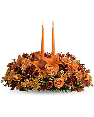 FAMILY GATHERING CENTERPIECE - As your loved ones gather around the table, they'll bask in the warm glow of two orange taper candles surrounded by a fantastic array of fall flowers. Orange roses, asiatic lilies, dark orange alstroemeria, bronze button spray chrysanthemums, yellow and rust cushion spray chrysanthemums and fall foliage are exquisitely gathered in this center-of-attention piece.  