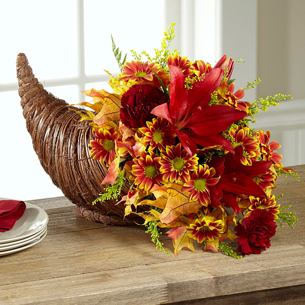 The Fall Harvest Cornucopia - A tradition passed down from generation to generation this modern take on the Thanksgiving cornucopia blossoms with an elegance and sophistication that will bring beautiful fall color and beauty to your holiday festivities in the style you have come to know and love. Eye-catching sunflowers and red Asiatic lilies take center stage surrounded by red roses bi-colored daisies burgundy carnations yellow solidago glycerized oak leaf stems and lush greens artistically arranged within a natural woven cornucopia horn-shaped basket. A simply stunning way to celebrate the spirit of gratitude family and friends that the Thanksgiving holiday conveys with those near to your heart but far from your home this harvest season. GOOD bouquet includes 8 stems. Approx. 13&quot;H x 10&quot;W. BETTER bouquet includes 12 stems. Approx. 16&quot;H x 13&quot;W. BEST bouquet includes 19 stems. Approx. 17&quot;H x 14&quot;W.