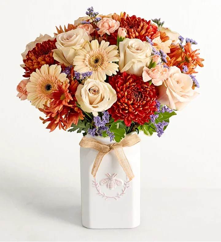 Honey Bee Buzz for Fall Honey Bee Buzz for Fall - Get them buzzing for fall! Our unique crescent-shape bouquet is gathered with a mix of blooms in a warm autumnal palette. Designed in our Sweet As Can Bee artisanal vase, featuring an adorable honeybee and a raffia bow, it’s a gift that adds seasonal beauty to any decor.