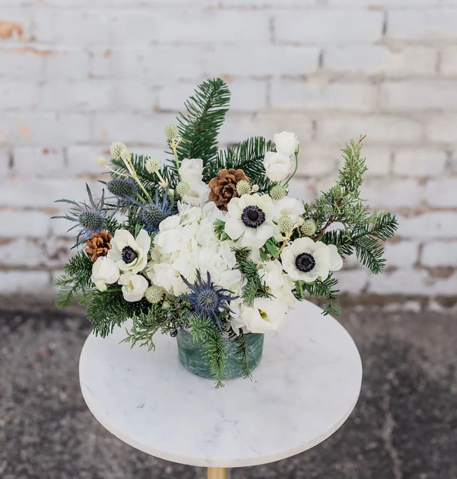 Blue Christmas - Cozy on up and Drink in the Holiday Spirit with our new Winter Collection! Designed to capture the essence of the holidays and bring joy to all. Blue Christmas is sure to invoke the frosty feelings of winter memories with your loved ones. Arranged with a stunning mix of fresh, blue &amp; white blooms, accompanied by winter greens and textures all elegantly designed in one of our hand-picked designer vases.  Pictured is [DELUXE]  *Some items in this arrangement must be special ordered, please allow 1-2 weeks notice to allow time for arrival of special items, otherwise, substitutions will occur.*