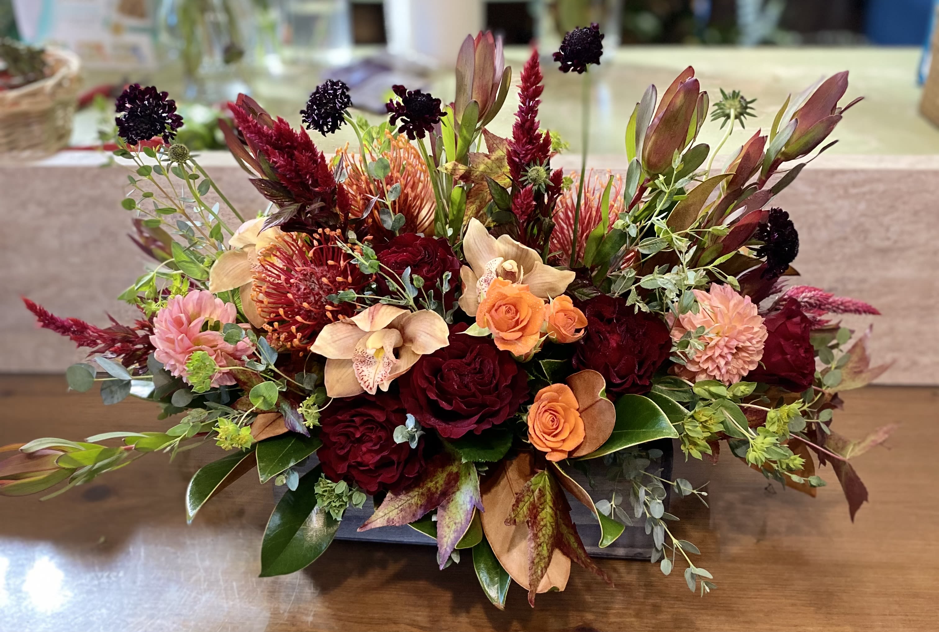 cabernet  - a lush fall arrangement in a wood box. includes orchids, roses, and safari