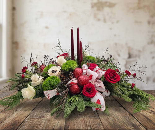 Traditional Christmas Flowers with Candles - Bring the spirit of the season into your home with our Traditional Christmas Flowers, handcrafted by your local florist in Olympia, WA. This festive arrangement features red and white roses, burgundy mini carnations, and green dianthus, beautifully accented with holiday ribbon, sparkling Christmas balls, and elegant candles for a warm, classic holiday display.  Perfect for dining tables, mantels, or holiday buffets, this centerpiece adds a cozy, festive glow to any space. Each arrangement is handcrafted and unique, making it a memorable gift or a stunning addition to your holiday décor.  We offer same-day flower delivery in Olympia, Tumwater, and Lacey, WA, ensuring your Christmas flowers arrive fresh and ready to delight. Celebrate the holidays with a classic floral arrangement that embodies elegance, warmth, and festive cheer.