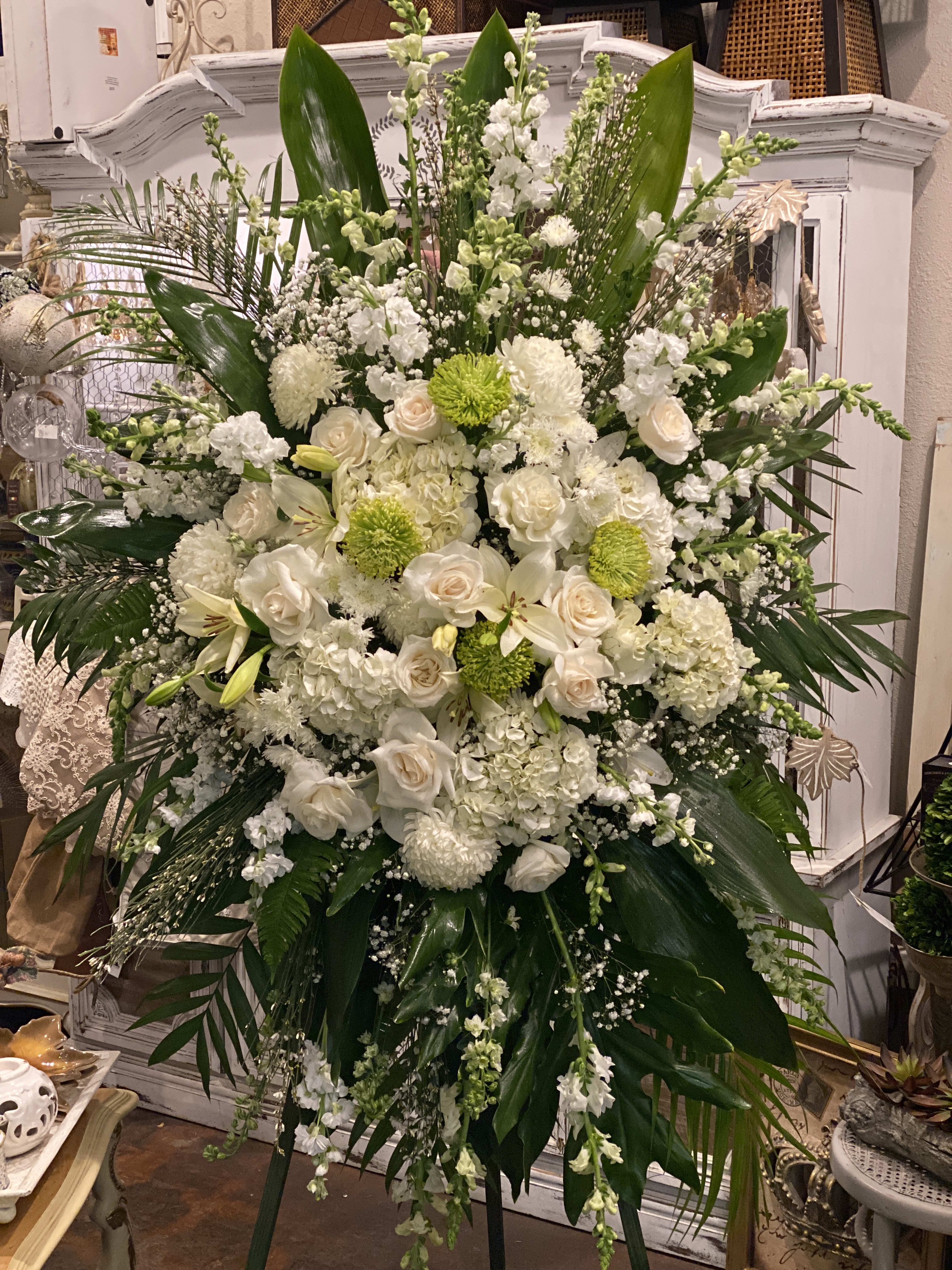 Tribute Standing Spray Tribute Standing Spray - Remind your loved ones that you are thinking of them during this time of sensitivity with a display of sweet serenity. Our  Tribute Standing Spray is elegantly crafted with roses, lilies, white hydrangea and accented with palm fronds. Each bloom in this grand arrangement shares your thoughtful condolences.