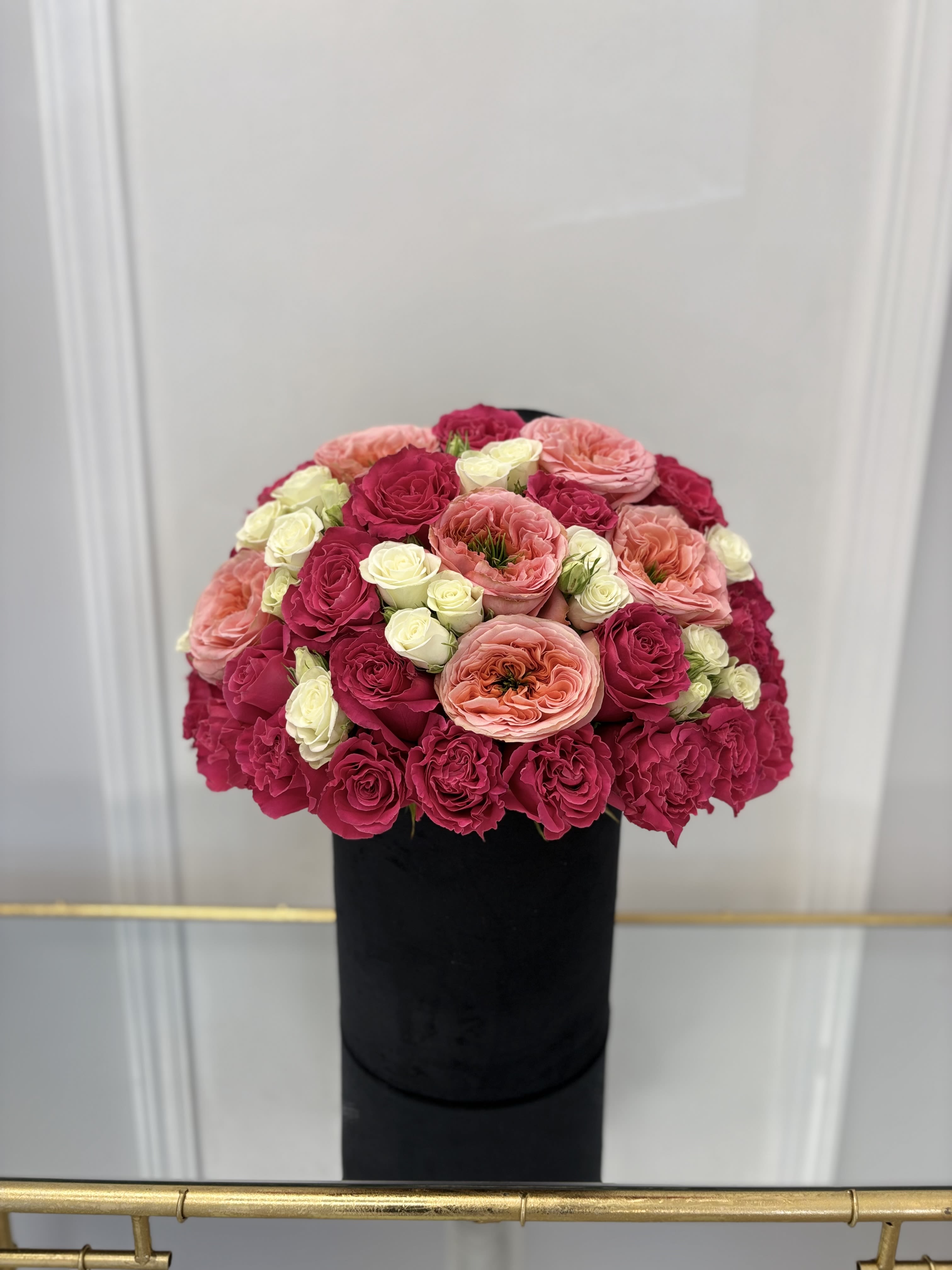 Coral And Hot Pink Hat Box By VLM Flowers - Coral garden roses are a combination of hot pink roses and white spray roses to raise the mood.