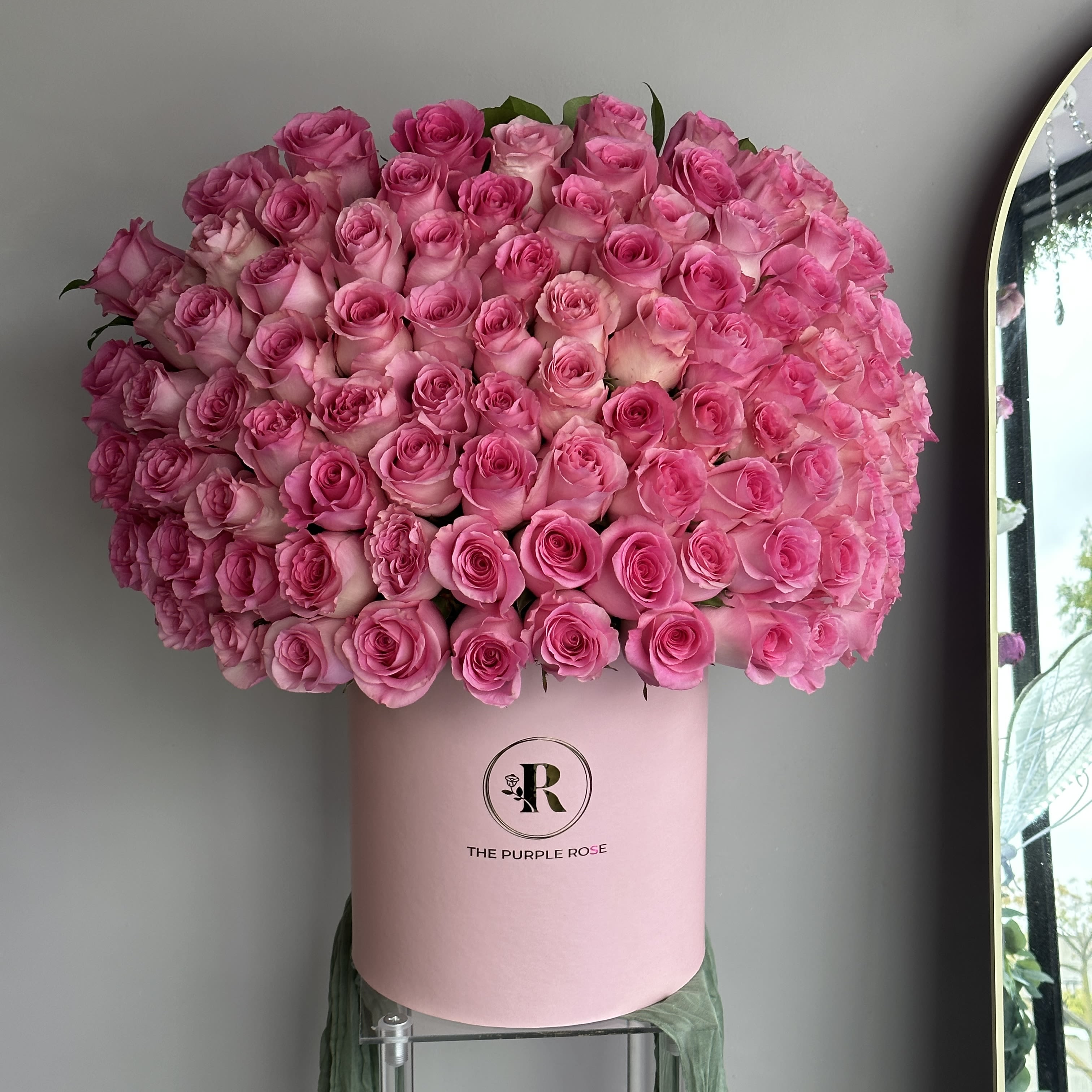 Pink Majesty - Premium Shown on the Photo Surprise someone special with an unforgettable sea of pink. Our Pink Majesty Arrangement features over a 100 fresh pink roses, hand-arranged in a signature blush hatbox from The Purple Rose. Each bloom is selected for its vibrant tone and long-lasting beauty, creating a statement piece that feels both luxurious and romantic. Perfect for upcoming Valentine's Day! 