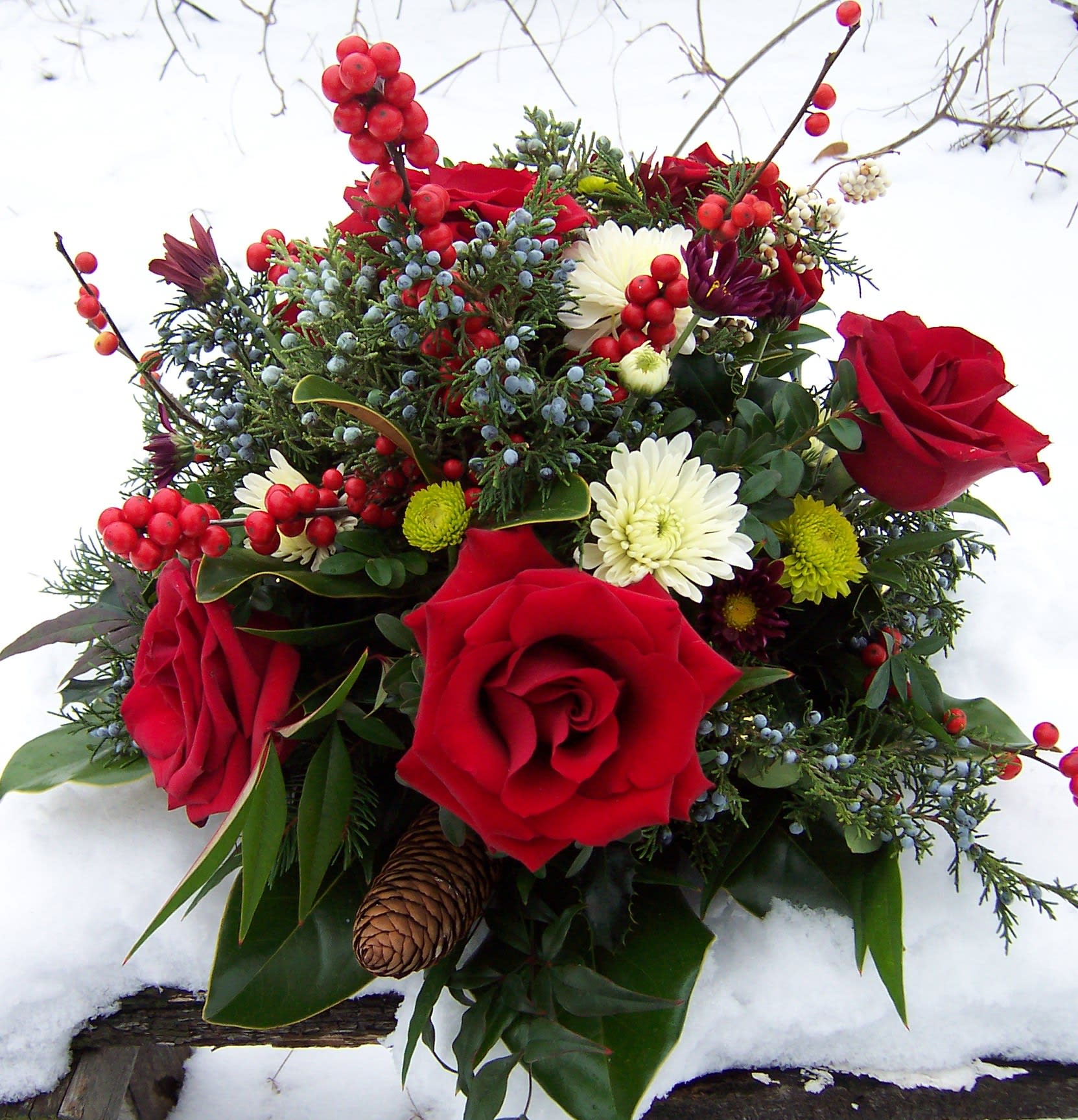 Holiday Display - Table centerpiece with roses, berries, magnolia, carnations and mums.