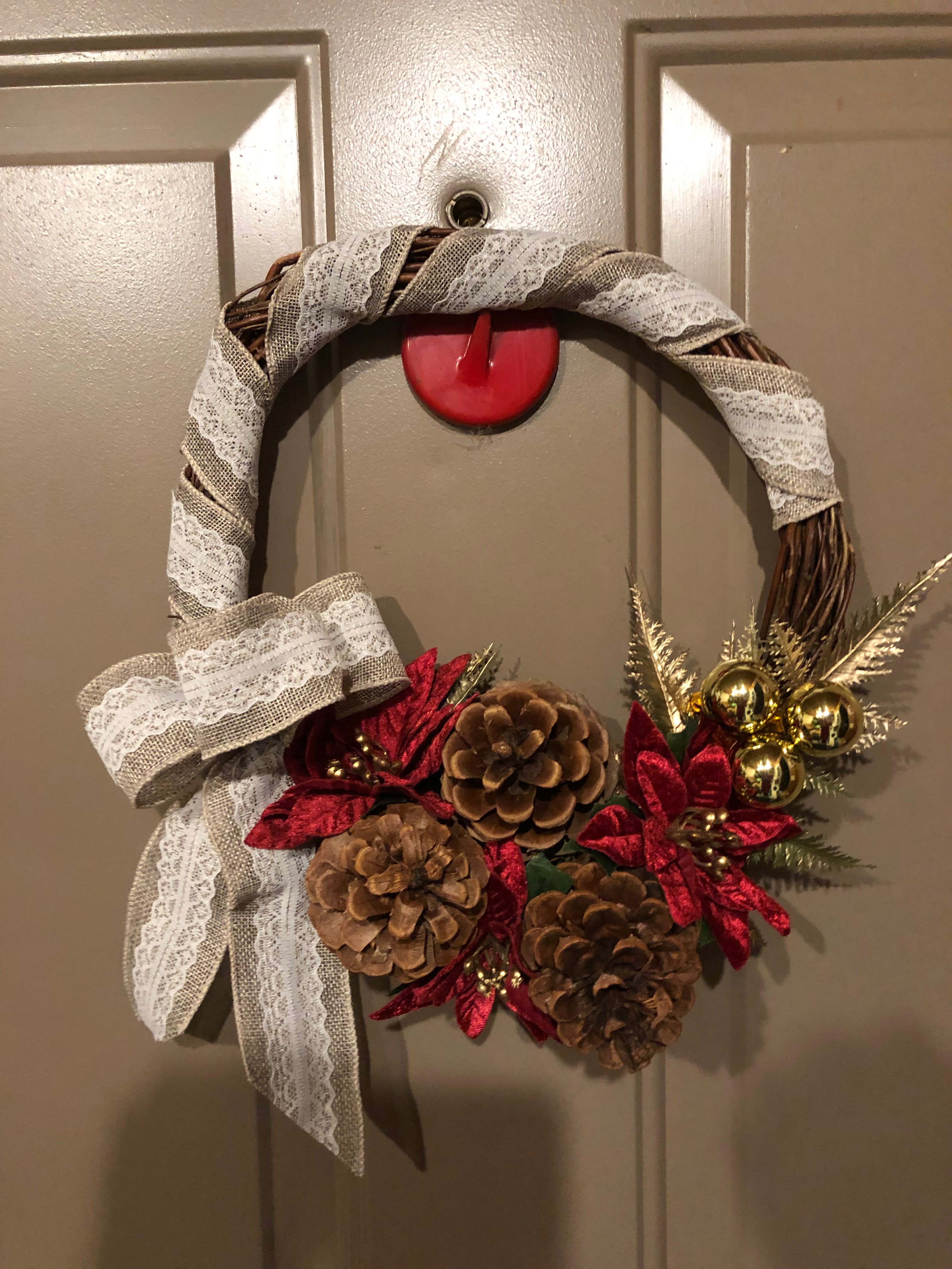 Holiday Wreath Holiday Wreath - Ribbon & lace, gold leaf tipped accents, pinecones, ornaments and poinsettias round out this one of a kind wreath. Would be a home hanging on the door inside or out. Great one of a kind gift for the hostess or host of your holiday parties. ( only 1 custom designed wreath available.) Approximately 10" X 12" oval. (hanger not included)