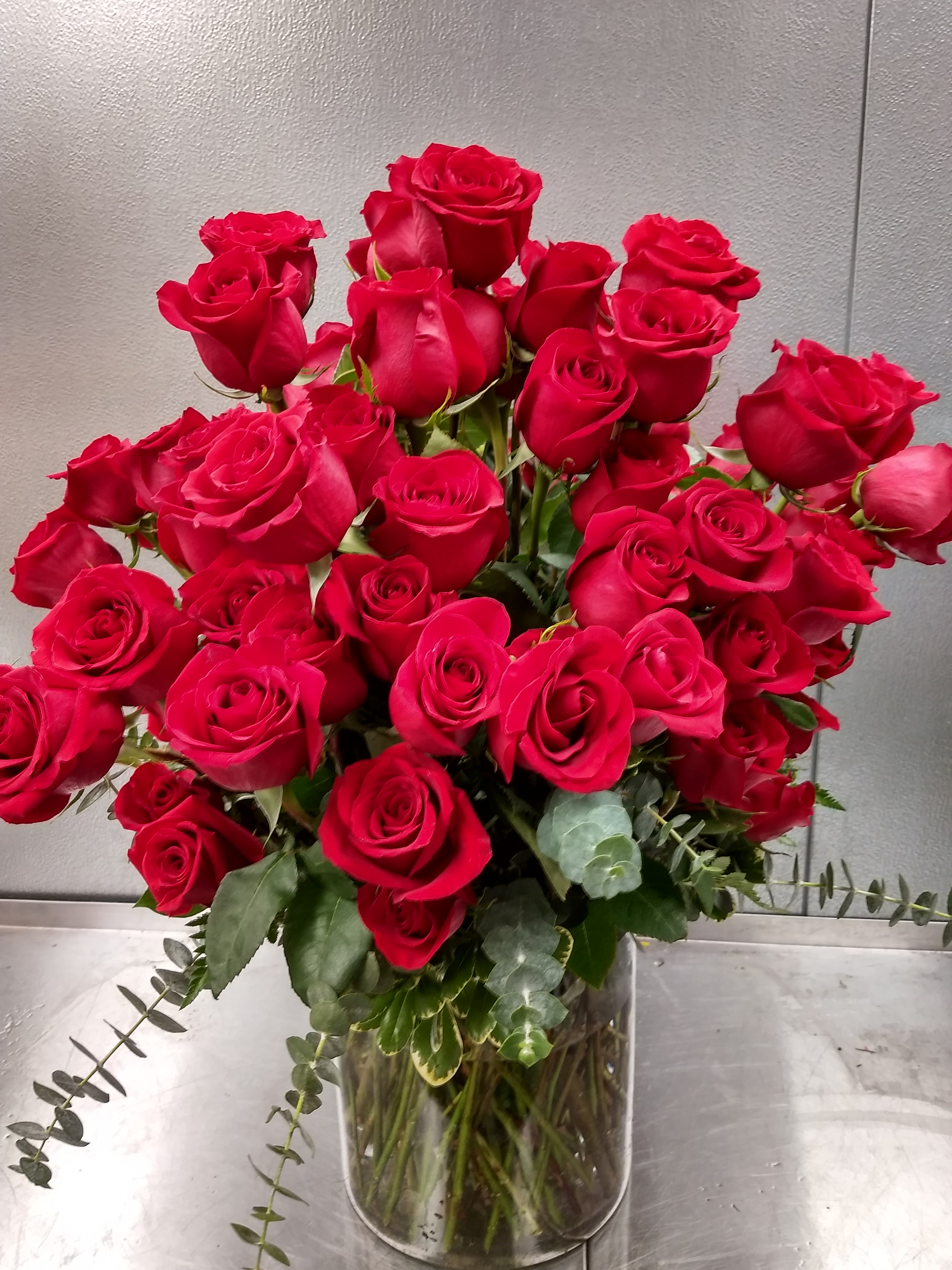 The ultimate - The ultimate, 100 premium  long stem red roses, arranged with assorted greens in a vase. A show stopper!   * Can be designed in red, white, pink, yellow or purple roses, call for details
