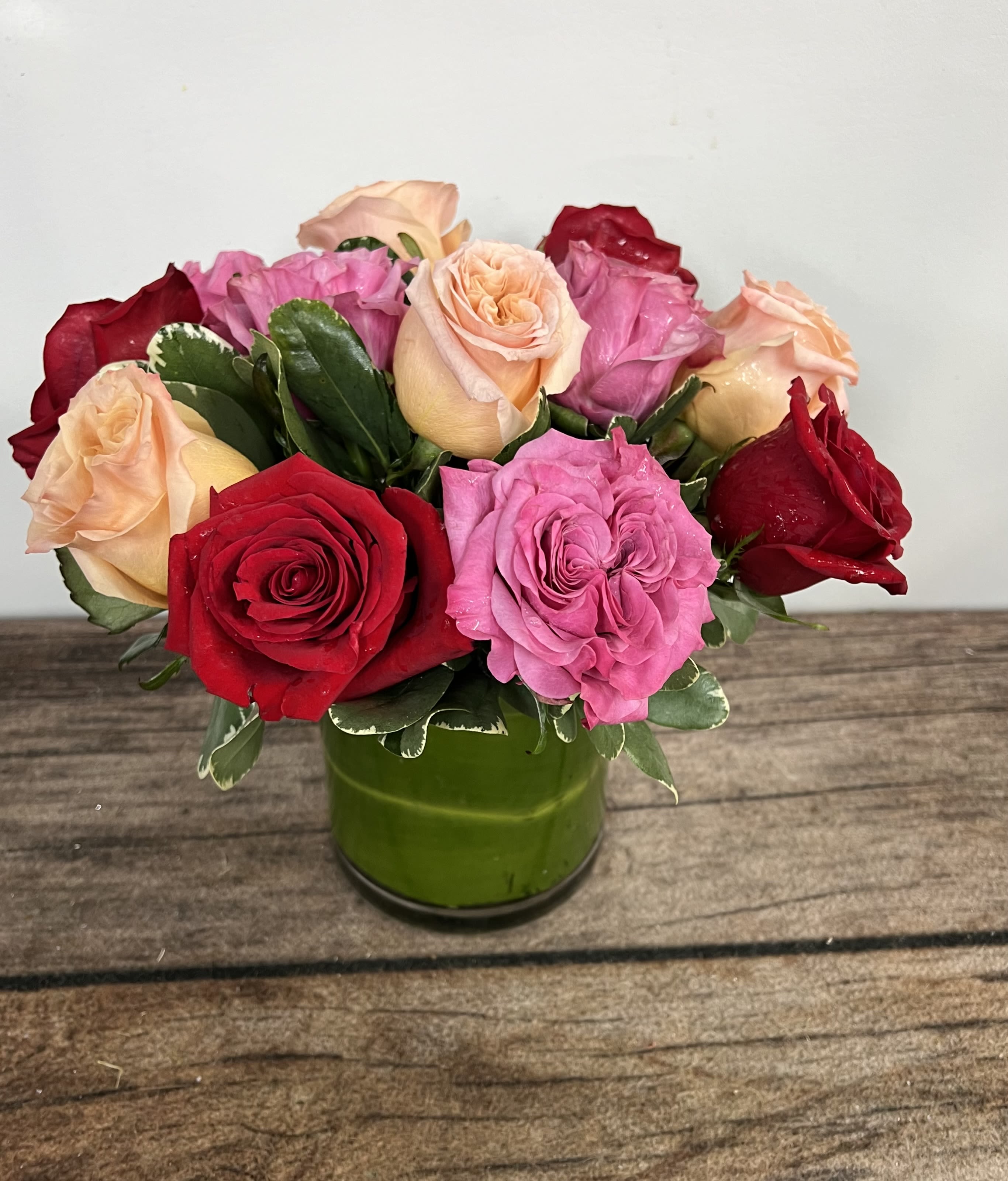 Posey - Lovely, complimenting shades of roses cut shorter in a bear grass lined vase. 