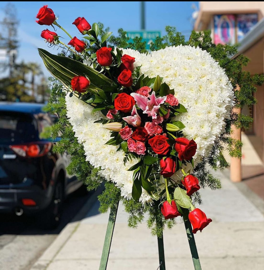 You will be forever missed You will be forever missed - Heart sympathy arrangement (white chrysanthemums) , with cluster of red roses, pink spray roses & stargazer lilies. Standing Easel is included with this arrangement.