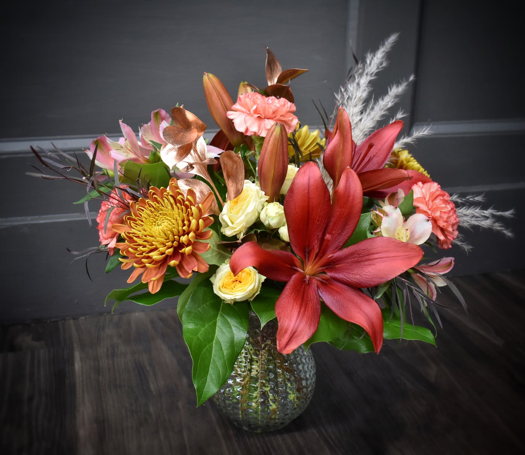 Fall Splash - A spinoff of our iconic Summer Splash, Fall Splash is its autumn twin. A mix of lilies, carnations, spray roses, mums, alstroemeria and pampas grass in warm colors to match the changing of the season. 