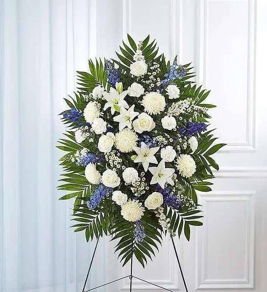 Blue &amp; White Sympathy Standing Spray - The Blue &amp; White Sympathy Standing Spray from DGM Flowers | Fort Lauderdale Florist is a beautiful floral tribute perfect for honoring a loved one. This standing spray features fresh cut flowers in shades of blue and white, elegantly arranged in a cascading design. Available in three options: Standard, Deluxe, or Premium, this standing spray is a heartfelt way to express your condolences and sympathy. The unique color combination and thoughtful design make this product a standout choice for funeral services or memorial gatherings. Honor your loved one with this stunning floral tribute today.