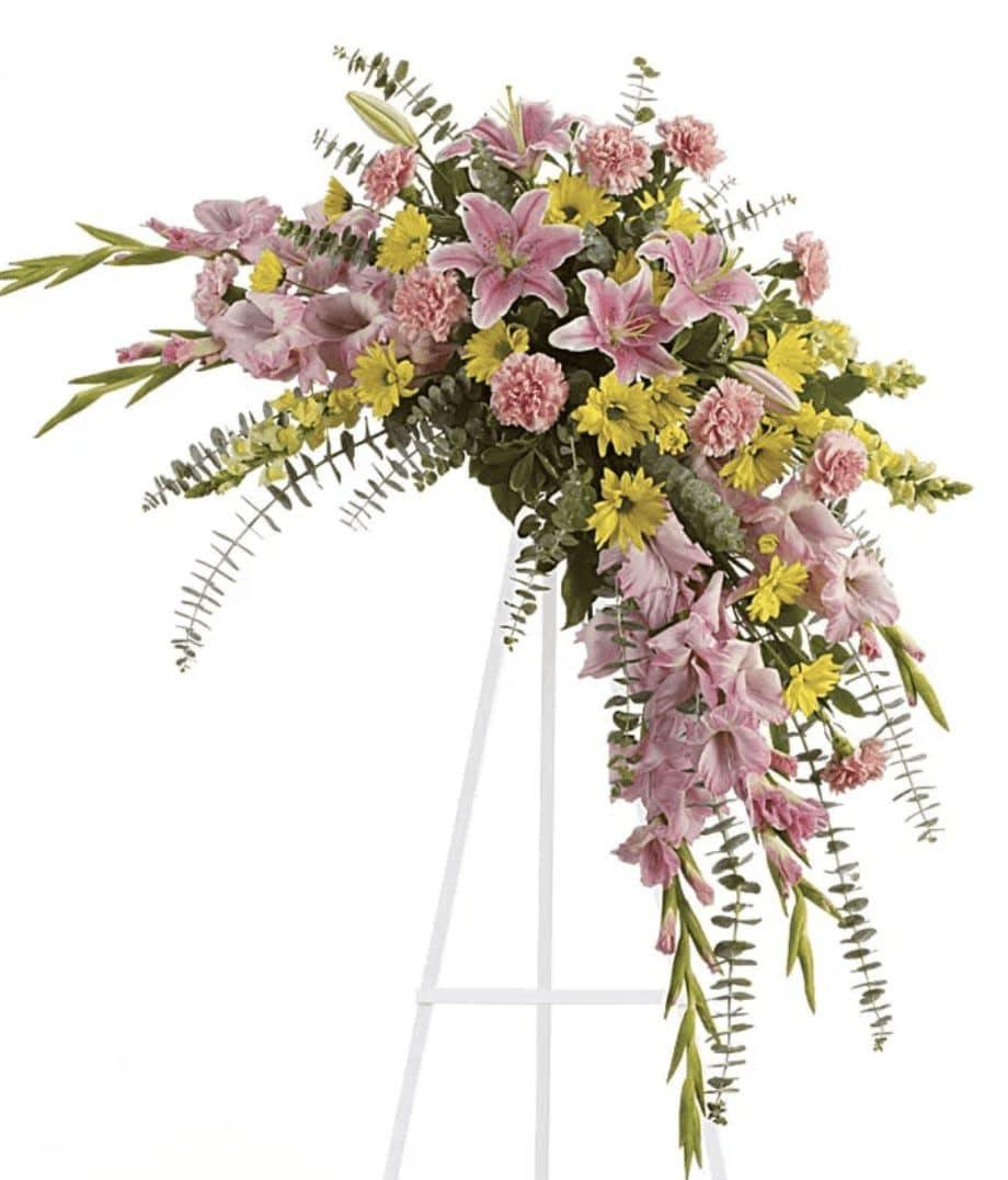 Sweet Solace Sympathy Spray - Soft, soothing pink lilies and yellow daisies are crafted into a crescent standing spray, what a lovely remembrance of your friendship, and perfect selection for a memorial service. This standing spray is created by DGM Flowers with beautiful pink and yellow flowers, delivered with a card message.  This elegant funeral flowers spray features a variety Includes:&nbsp; • Pink Oriental Lilies&nbsp; • Gladioli&nbsp; • Pink Carnations&nbsp; • Yellow Snapdragons&nbsp; • Eucalyptus