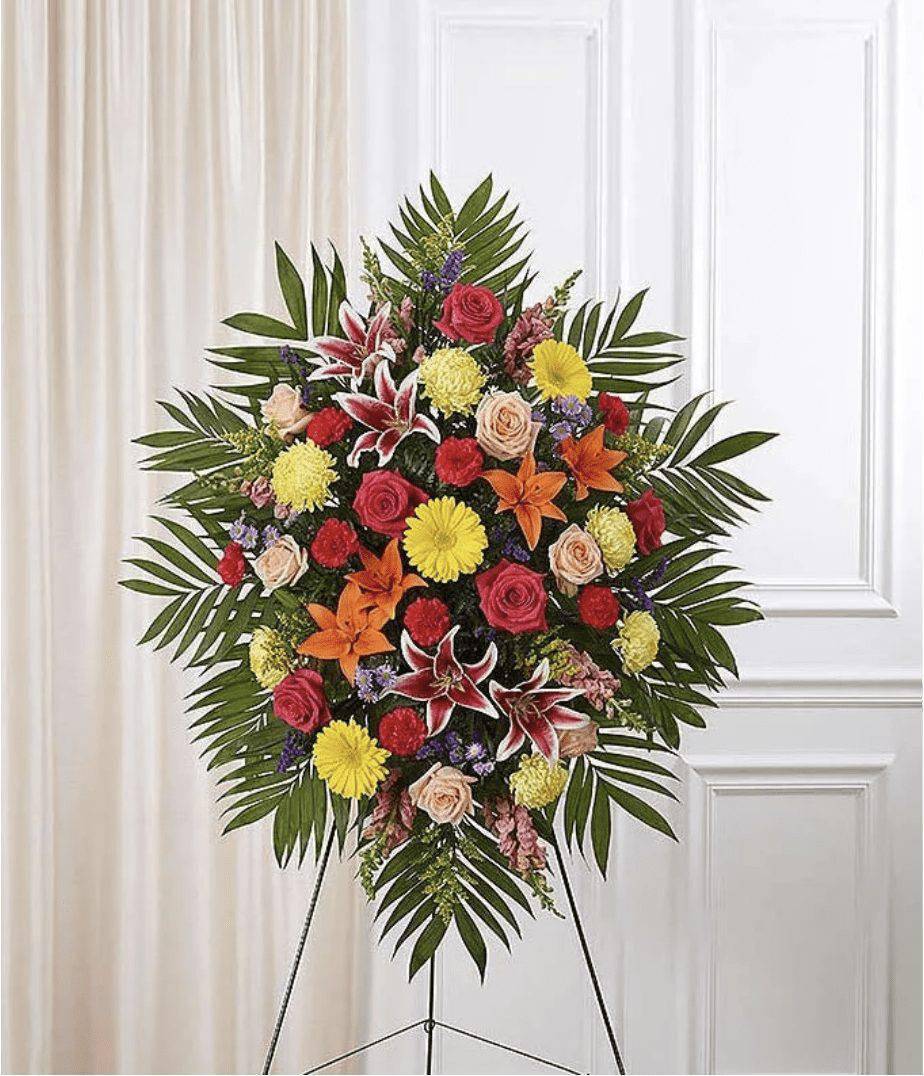 Multicolor Bright Sympathy Standing Spray - Send your sympathy with a colorful and bright floral oval standing spray. The arrangement has seasonal re roses, orange lilies and snapdragons in the beautiful colors of peach and pink. Standing sprays are an appropriate gift for family, friends or co-workers to send to a funeral home. Colors and varieties may vary on. Medium measures approximately 46&quot;H x 38&quot;L.  Includes: • Roses, Lilies, Mums &amp; Snapdragons • Peach &amp; Pink Color Theme   --   Send your sympathy with a colorful and bright floral oval standing spray. The arrangement has seasonal re roses, orange lilies and snapdragons in the beautiful colors of peach and pink. Standing sprays are an appropriate gift for family, friends or co-workers to send to a funeral home. Colors and varieties may vary on. Medium measures approximately 46&quot;H x 38&quot;L.  Includes: • Roses, Lilies, Mums &amp; Snapdragons • Peach &amp; Pink Color Theme