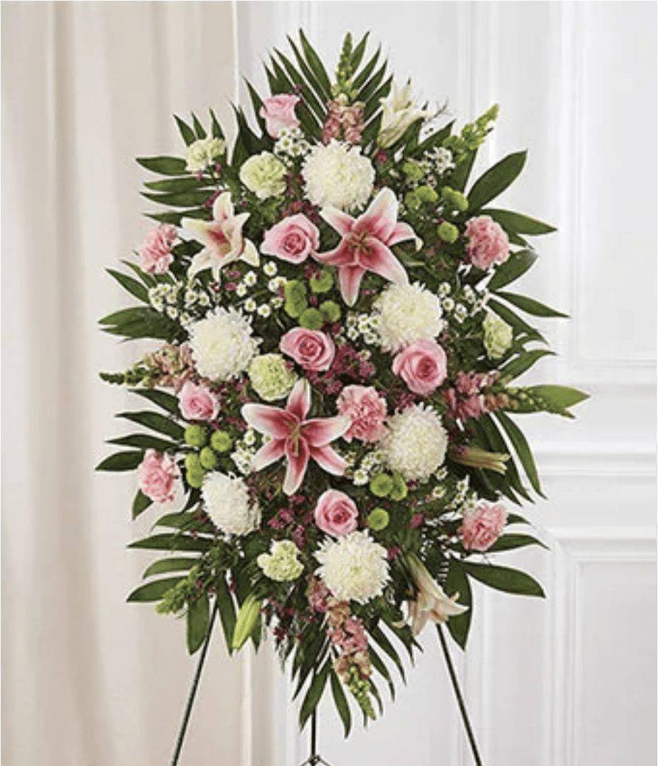 Multicolor Pastel Sympathy Standing Spray - The Multicolor Pastel Sympathy Standing Spray by DGM Flowers | Fort Lauderdale Florist offers a beautiful and heartfelt tribute for honoring a loved one. Send a sympathy floral standing spray created by a local florist, hand delivered. Seasonal flowers are arranged in this beautiful gift to show your care and concern; pastel roses, lilies, mums, snapdragons and more. Standing sprays are an appropriate gift for delivery from a family member, friend or co-worker. Showcasing a blend of calming colors and elegant blooms, the Multicolor Sympathy Standing Spray is a touching way to express your condolences and offer support to those who are grieving. Delivery is available directly to a funeral home from our flower studio. &nbsp;Medium (shown) measures approximately 46&quot;H x 38&quot;L.  Includes:&nbsp; • Pink Roses&nbsp; • Pink Lilies&nbsp; • Pink Snapdragons&nbsp; • White Mums&nbsp; • Pink and Green Carnations&nbsp; • Bells of Ireland&nbsp; • Green Button Poms&nbsp;