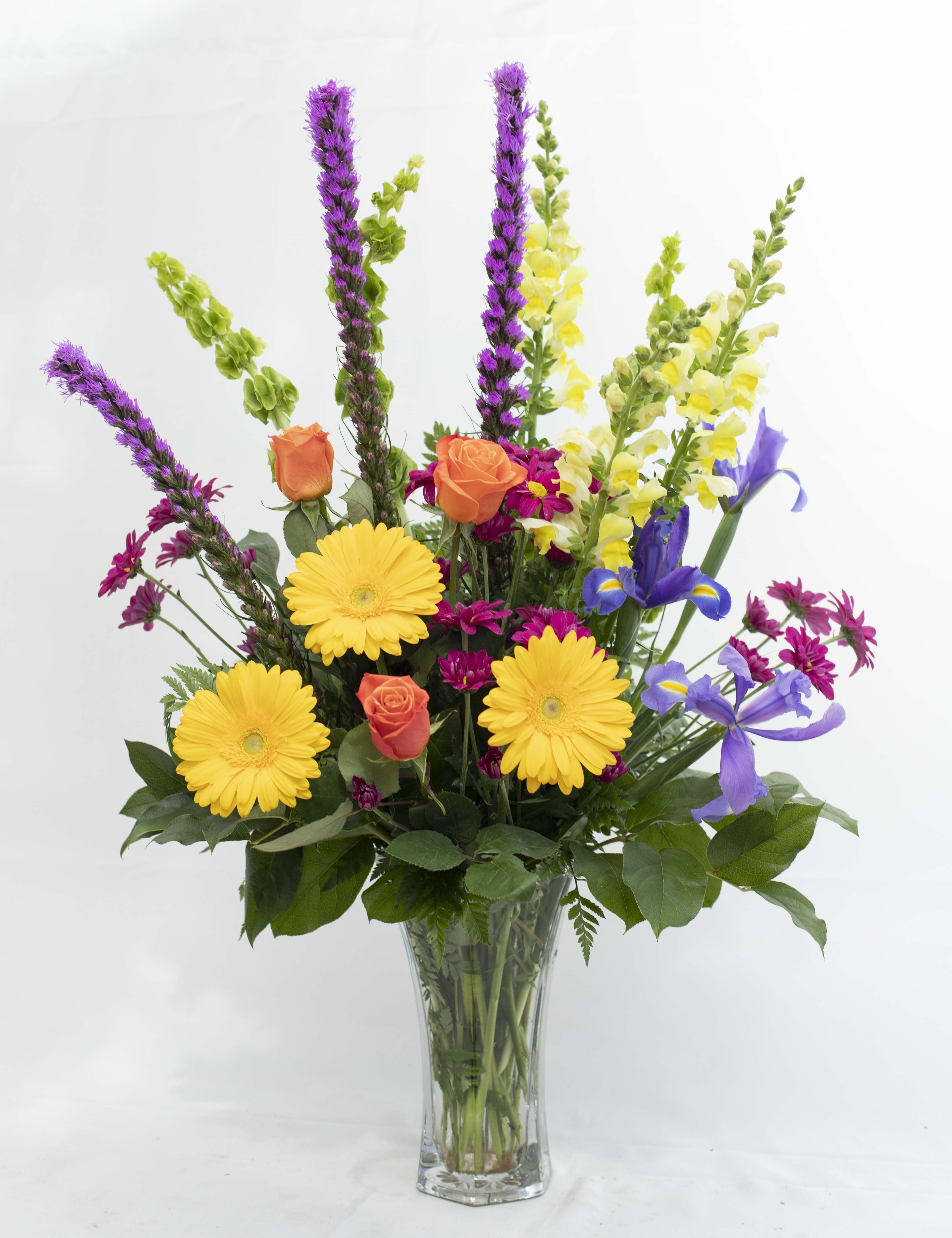 Vibrant Remembrance - A simple vase of colorful flowers  to express the remembrance of a loved one. Snapdragons, Bells, Gerbera, Iris, Liatris ,Roses and Daisies stand tall in this 3 sided arrangement.