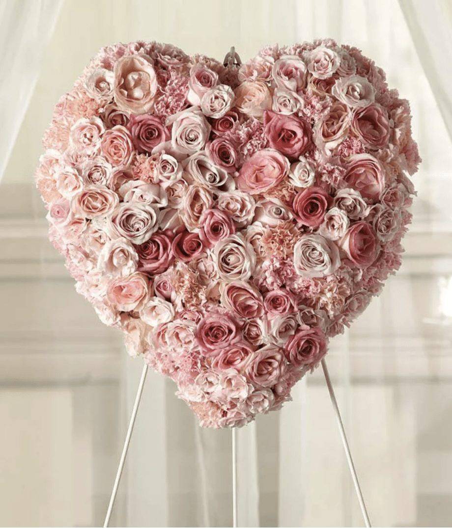 Graceful Heart Solid Spray - The Graceful Heart Solid Spray from DGM Flowers | Fort Lauderdale Florist is a stunning tribute of delicate pink roses and carnations fill this heart shaped arrangement for a graceful expression of sympathy. This Solid Heart Funeral Spray is a unique and heartfelt way to honor a loved one.The Graceful Heart Solid Spray is a thoughtful choice for expressing your condolences and sympathy during a difficult time. This arrangement is traditionally sent directly to the funeral home to be displayed on a stand. Measures approximately 23&quot;H x 24&quot;W x 6&quot;D.  Includes:&nbsp; • Pink Rose Variety&nbsp; • Pink Spray Roses&nbsp; • Pink Carnations&nbsp; • Standing Heart&nbsp; • Florist Arranged &amp; Delivered  