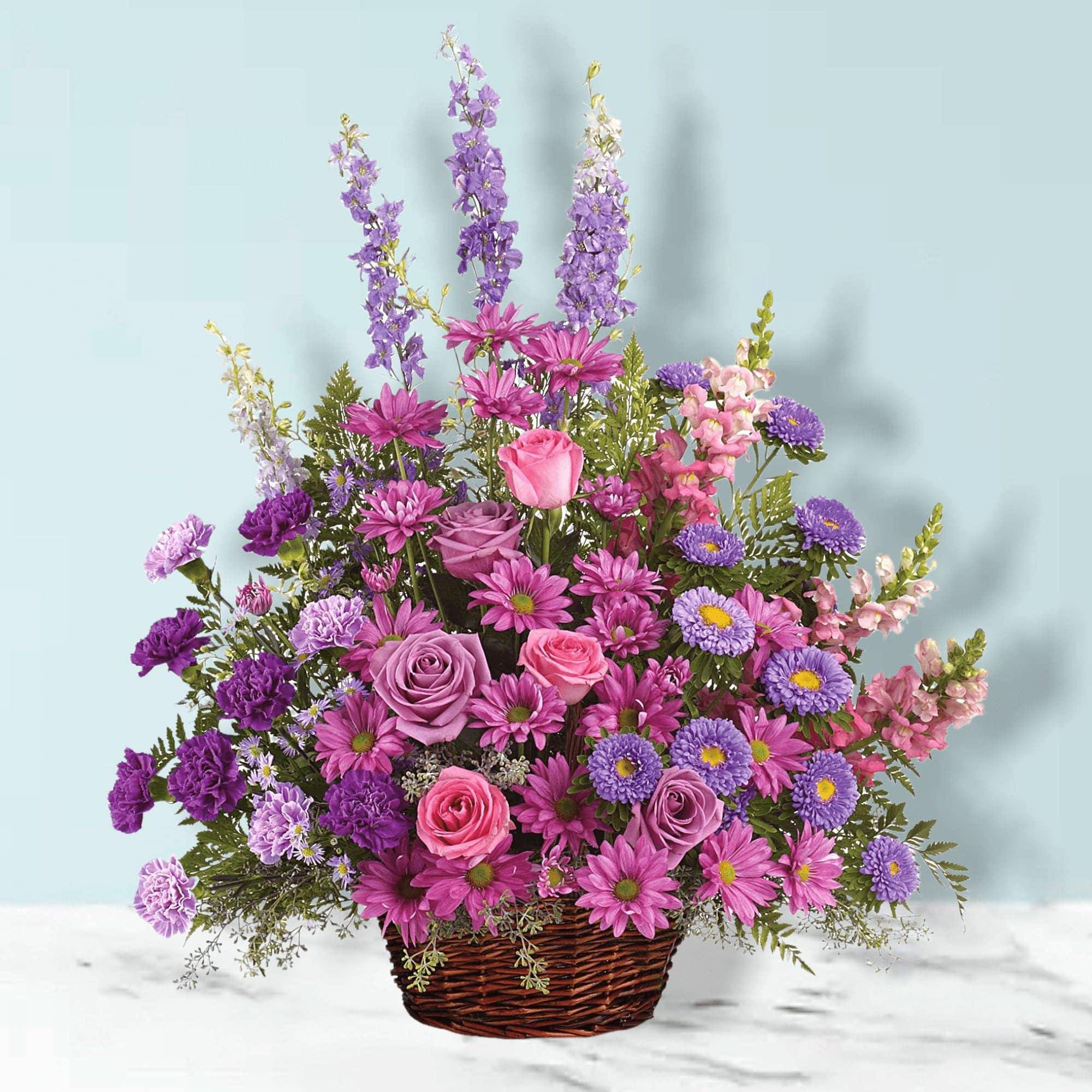 Gracious Lavender Basket - The Gracious Lavender Basket features Soothing lavender, respectful purple and compassionate pinks are combined beautifully in this basket overflowing with pretty flowers. This Lavender Flower Basket is perfect for any occasion, from birthdays to anniversaries, to express your heartfelt sentiments. A lovely way to share your thoughts and pay tribute to someone special.  A profusion of purple, pink and lavender blooms such as roses, carnations, larkspur, matsumoto and monte casino asters and much more are delivered in a round wicker basket.  Orientation: One-Sided  Standard Measures Approximately 24 1/2&quot; W x 28&quot; H, Deluxe Measures Approximately 27 3/4&quot; W x 28 1/2&quot; H, Premium Measures Approximately 27 3/4&quot; W x 28 1/2&quot; H