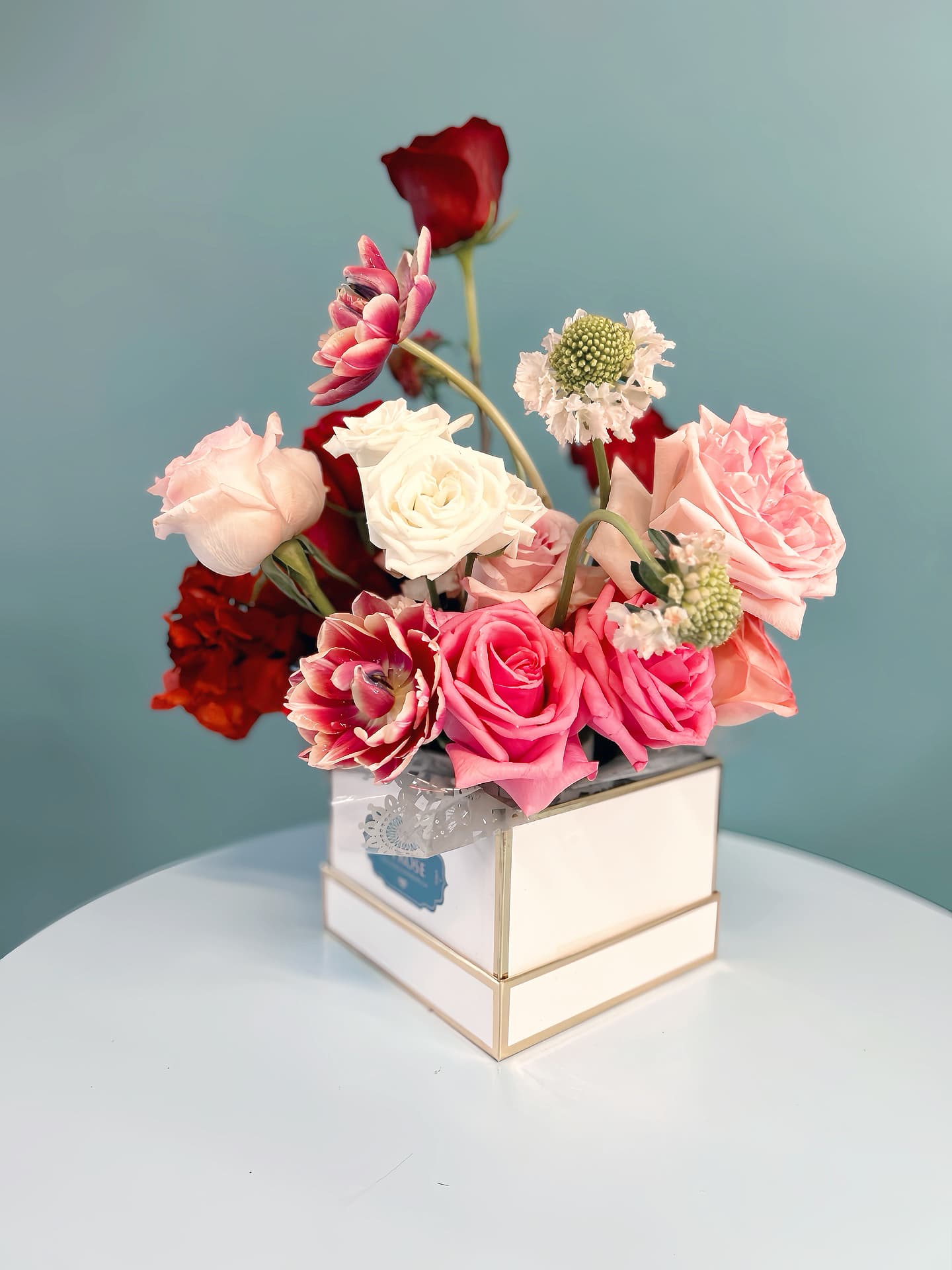 Spring Flower Box - Celebrate the beauty of spring with our premium floral arrangement, featuring a delightful mix of fresh, seasonal spring blooms combined with lush foliage. Expertly arranged in a ceramic or glass container, each bouquet captures the essence of the season. To enhance the experience, your arrangement comes beautifully presented in an artistic luxury flower box, adding a touch of elegance and making it perfect for gifting or décor. Bring the freshness of spring into any space with this stunning floral display.  You choice of theme and colour preference, please leave us a note at check out.  standard size : 14-16 stems of florals deluxe size:  20-24 stems of florals premium size:  36-40 stems of florals  Leave us a note at checkout with your preferred color theme and floral variety. While we cannot guarantee an exact match, we will make every effort to design your arrangement as closely as possible to your request.