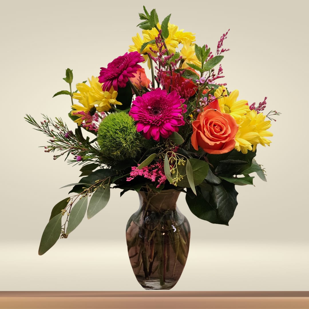 Brighten Their Day - Looking for a cheerful and colorful floral gift? Our Brighten Their Day Vase Arrangement is the perfect choice to lift someone’s spirits or celebrate a special occasion. Designed with vibrant hot pink Gerbera daisies, sunny yellow daisies, and bold orange roses, this arrangement is full of joy and warmth. It's a wonderful way to say happy birthday, get well soon, or simply thinking of you.  This medium-sized vase is ideal for displaying on a kitchen counter, dining table, or office desk—bringing beauty and brightness to any space.  At Specialty Floral Design, we specialize in creating one-of-a-kind flower arrangements for all occasions. Each bouquet is thoughtfully handcrafted in our Olympia, WA, floral studio using the freshest seasonal blooms.  We proudly offer flower delivery in Olympia, Tumwater, Lacey, and surrounding areas. Whether you're sending flowers locally or planning a surprise for a friend or loved one, our professional floral delivery ensures your arrangement arrives fresh and full of life.  Send a gift that speaks volumes with this joyful vase arrangement from your local Olympia florist—Specialty Floral Design.  