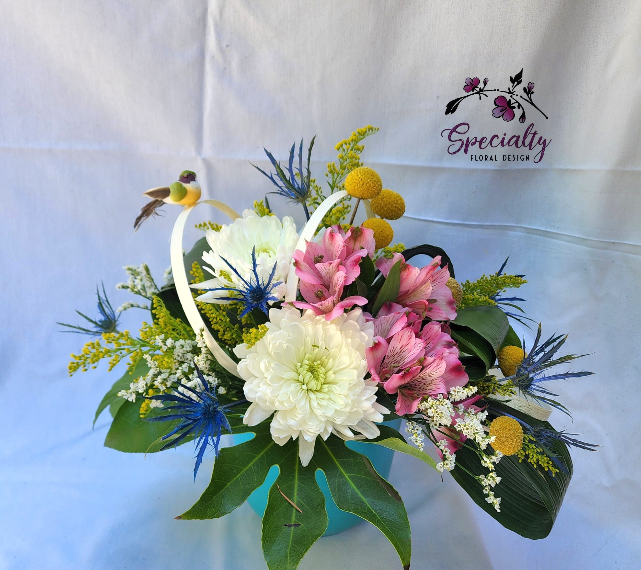 Little Birdie Told Me - Little Birdie Told Me Bouquet  Brighten someone's day with the playful and vibrant Little Birdie Told Me Bouquet. Bursting with fun colors and cheerful blooms, this arrangement is perfect for birthdays, get-well messages, or simply to spread a little joy. Featuring yellow solidago, white cremones, pink alstroemeria, and eye-catching Craspedia, this bouquet is a delightful choice for any occasion.  Product Information:  - Flowers Included: Yellow solidago, white cremones, pink alstroemeria, Craspedia.    - Please note the container could come in pink, blue, green, or yellow  About Specialty Flora Design Located in the heart of Olympia, WA, Specialty Flora Design is more than just a flower shop. We are creators of memories and conveyors of emotions, serving Olympia as well as the neighboring communities of Tumwater, Lacey, Shelton, and Chehalis. Our floral masterpieces encapsulate emotions and celebrate life’s special moments, crafted with care by expert florists. 