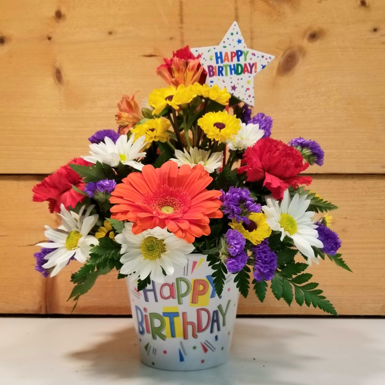 Birthday Brights - The Birthday Brights by Savilles Country Florist is a burst of Birthday goodness with fun bright colors presented in a colorful &quot;Happy Birthday&quot; container and accented with a Birthday pick.  A wonderful gift idea that is sure to bring a smile!  Approx. 12&quot; H x 10&quot; W