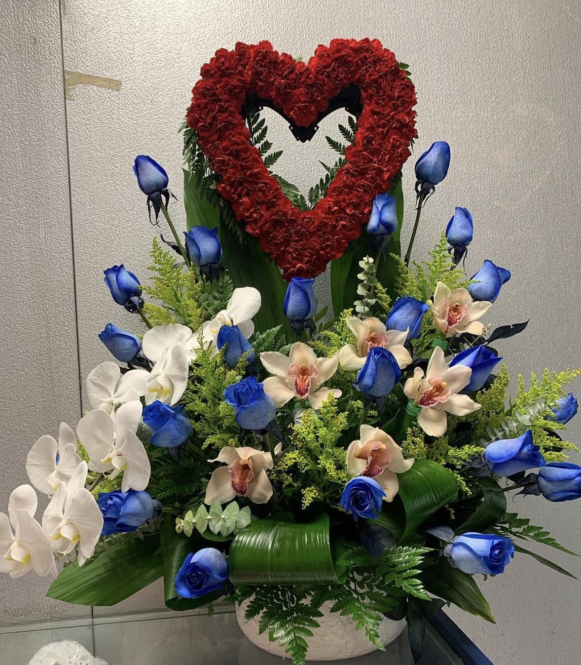 You are My love - Love Extravaganza!!! Spectacular floral arrangement designed with blue roses, orchids cymbidium, orchids phalaenopsis and a heart of red carnations. Unique and different ideal for any occasion Valentines Day, mother's day, birthday, anniversary