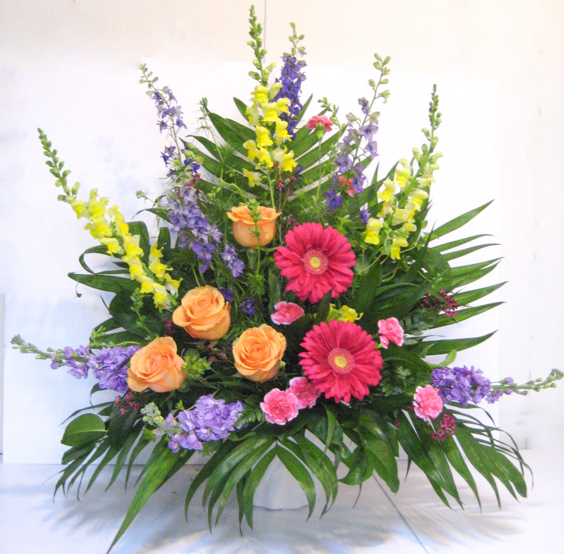 Colorful Tribute - A combination of customers favorite blooms, Snapdragon, Gerbera Daisies, Stock, Larkspur, and Roses, 