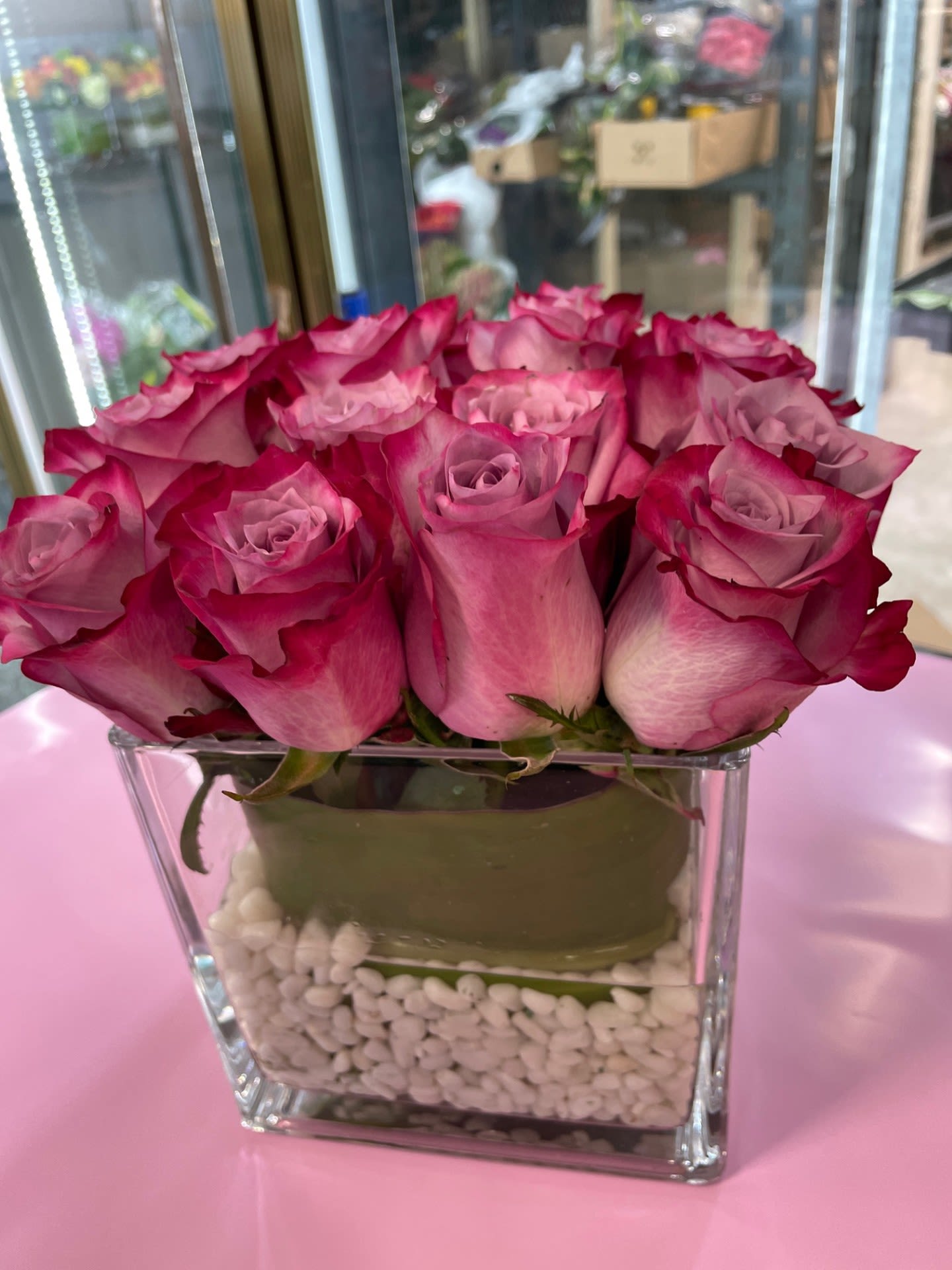 Purple 16 - Purple Roses arranged in 6X6 Glass vase lined and decorative pebbles 